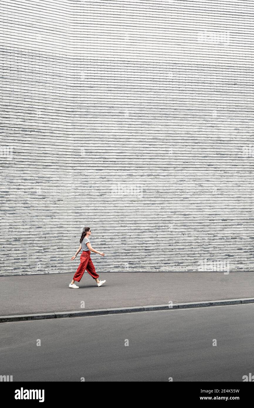 Woman walking sidewalk gray wall hi-res stock photography and images ...