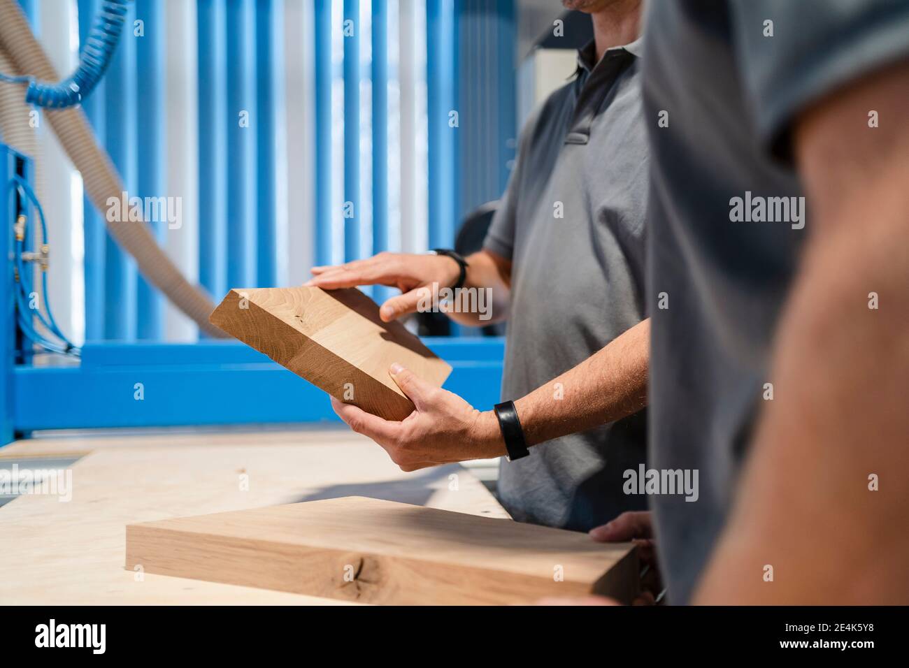 Mid sections of two carpenters examining planks of wood Stock Photo