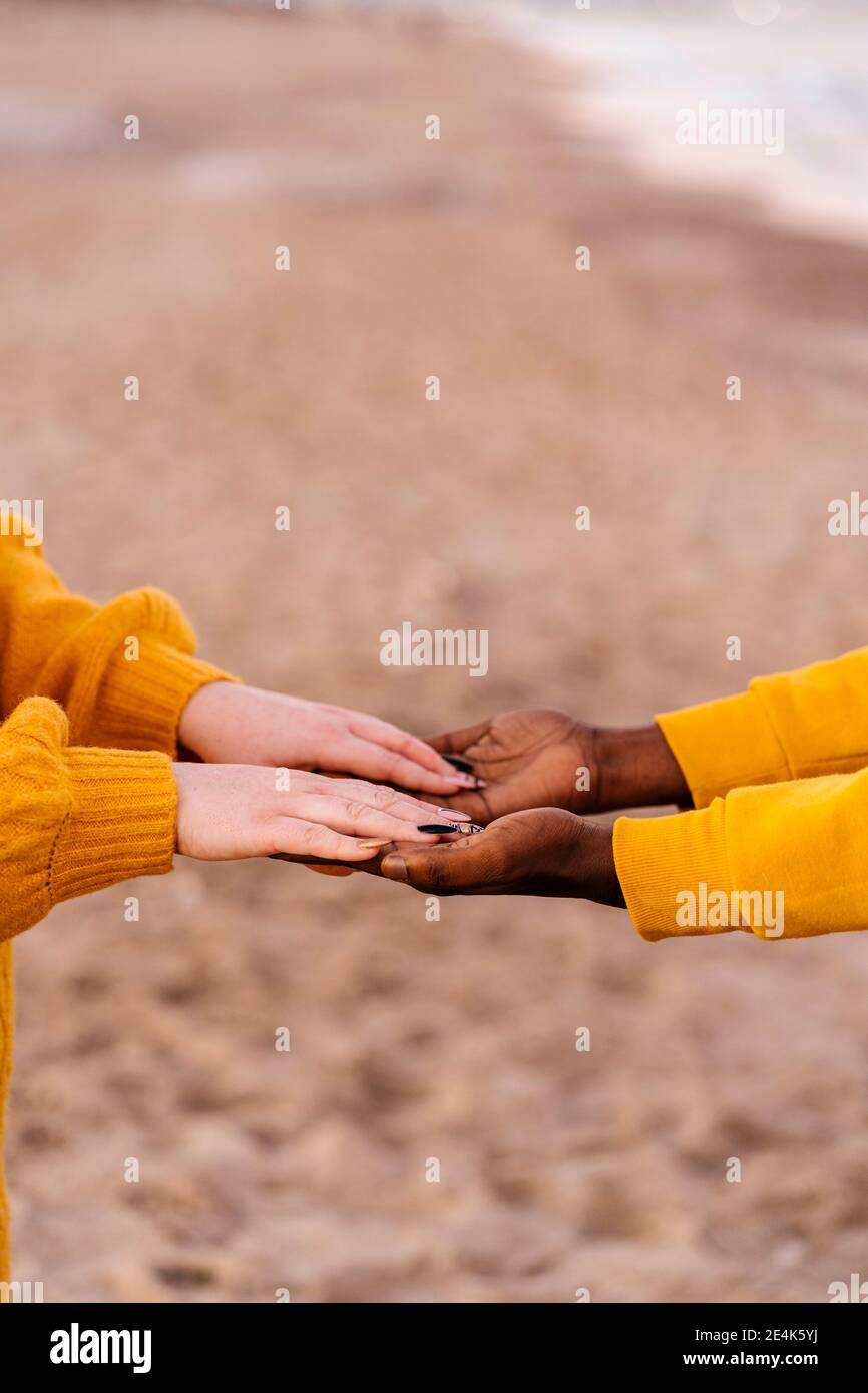 Close-up of man and woman hands clasped at beach Stock Photo