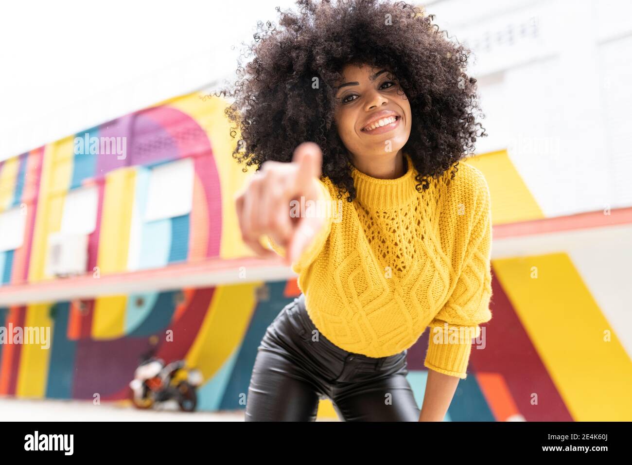 Smiling woman pointing finger while standing outdoors Stock Photo