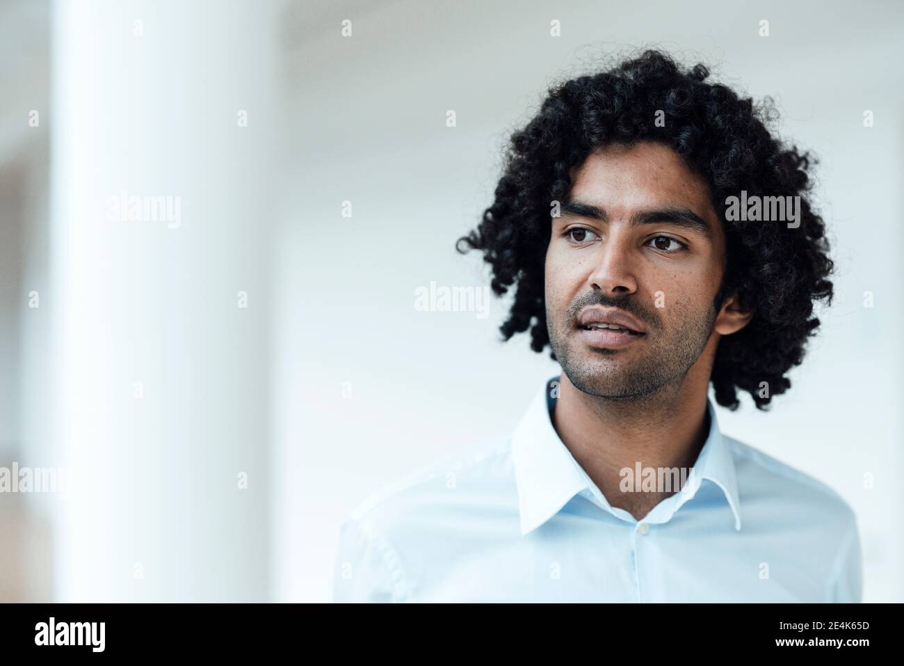 Thoughtful Young Male Entrepreneur With Curly Black Hair Looking Away At  Office Stock Photo - Alamy
