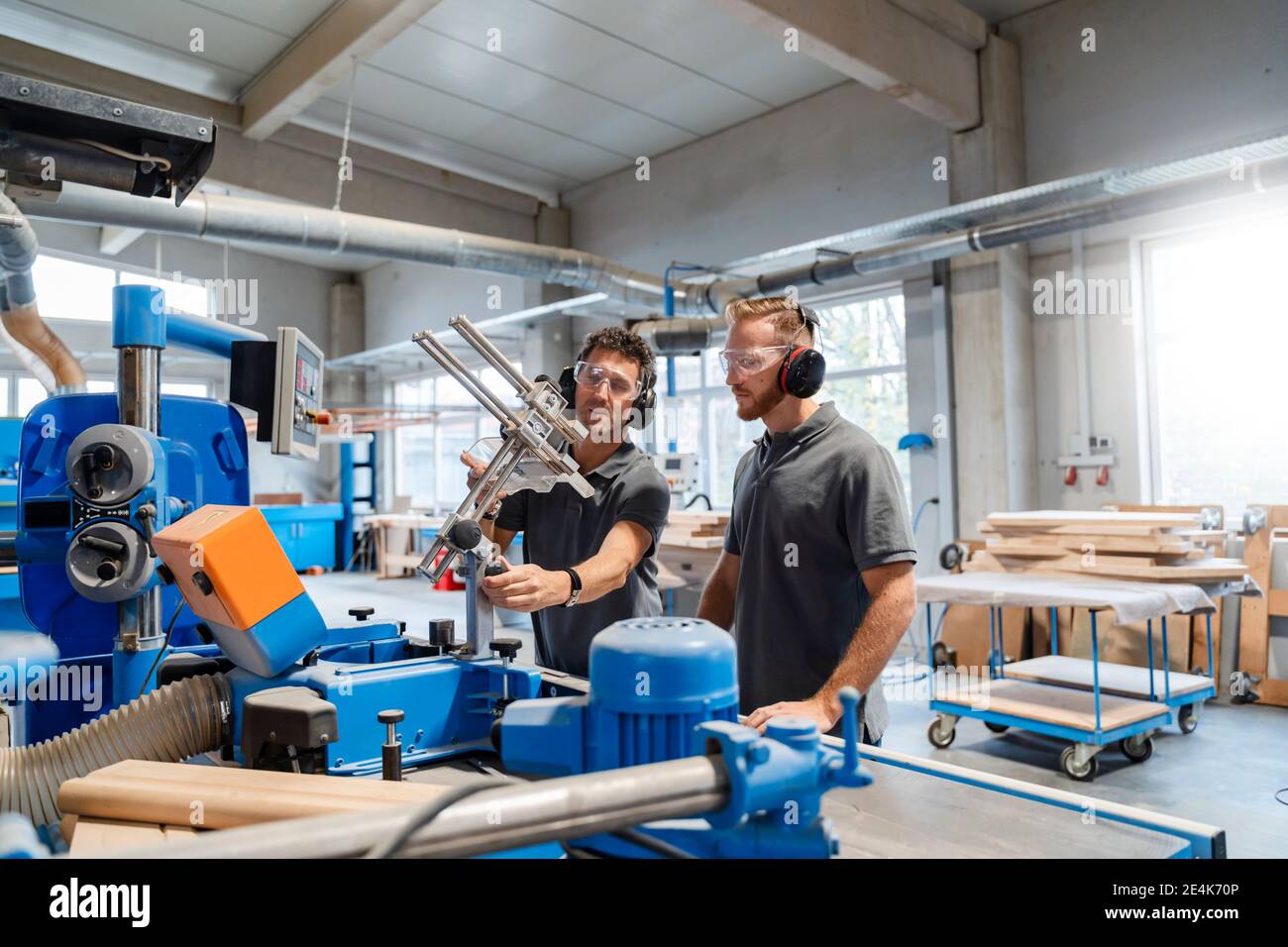 Two male carpenters talking in production hall Stock Photo - Alamy