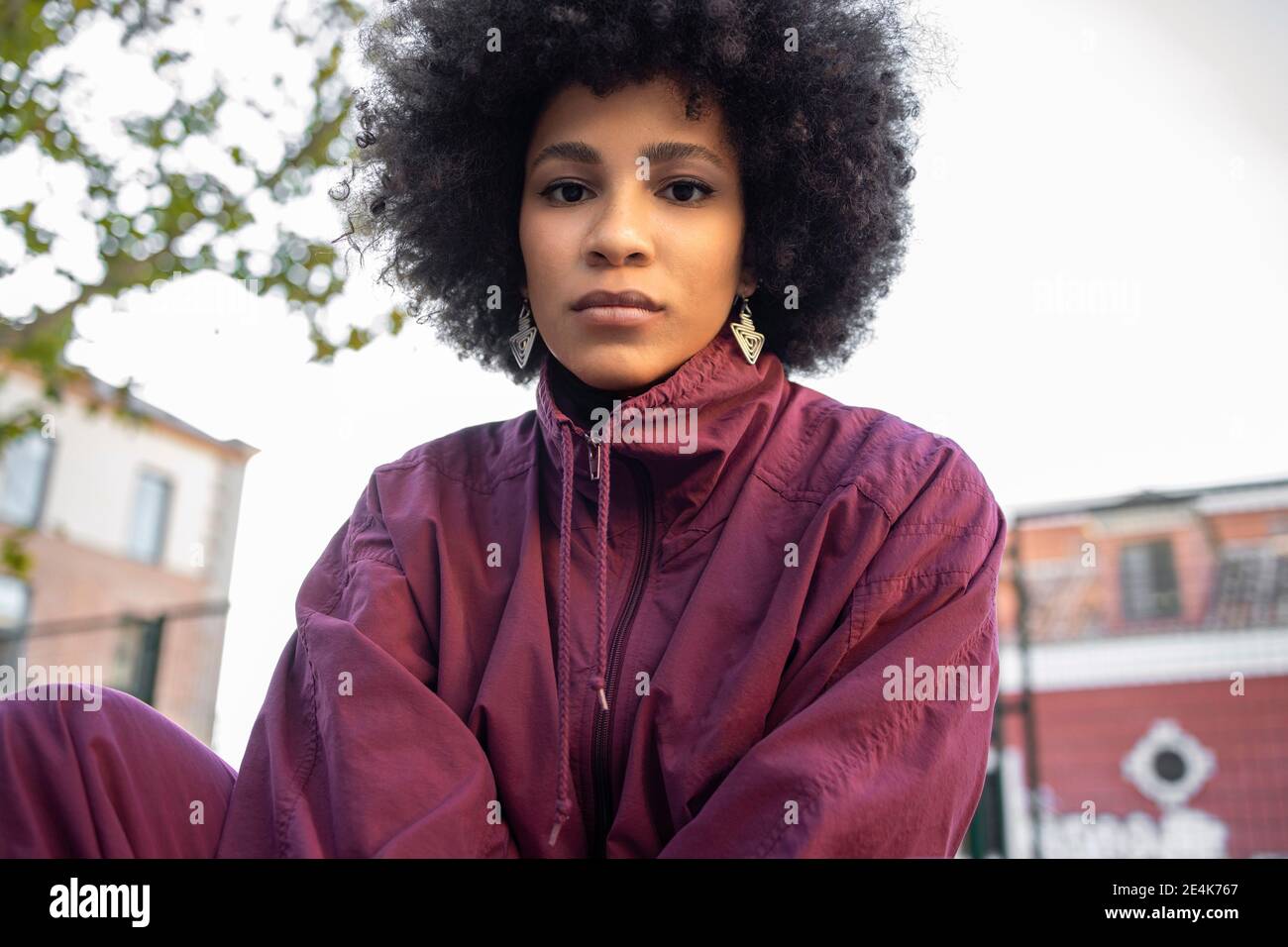 Smiling afro woman gesturing against clear sky Stock Photo - Alamy