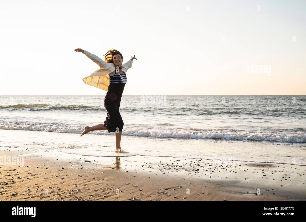 Woman sunset beach carefree hi-res stock photography and images - Alamy