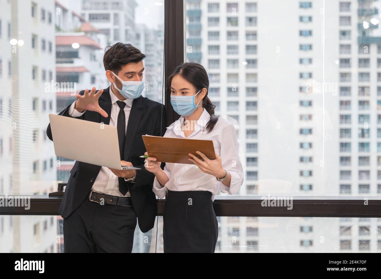 Multi ethnic business colleague wearing face mask discussing and ...