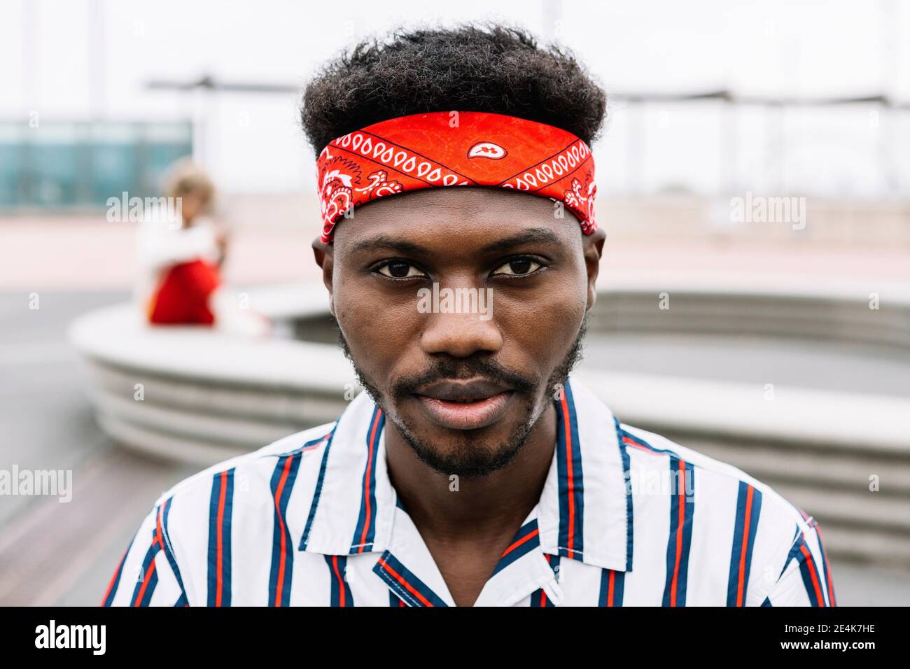 Man wearing headband staring while sitting outdoors Stock Photo