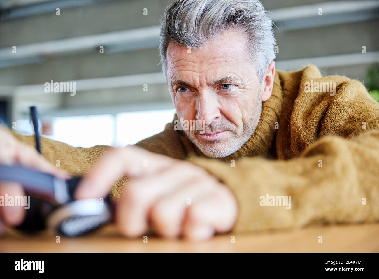 Man repairing headset while sitting at office Stock Photo