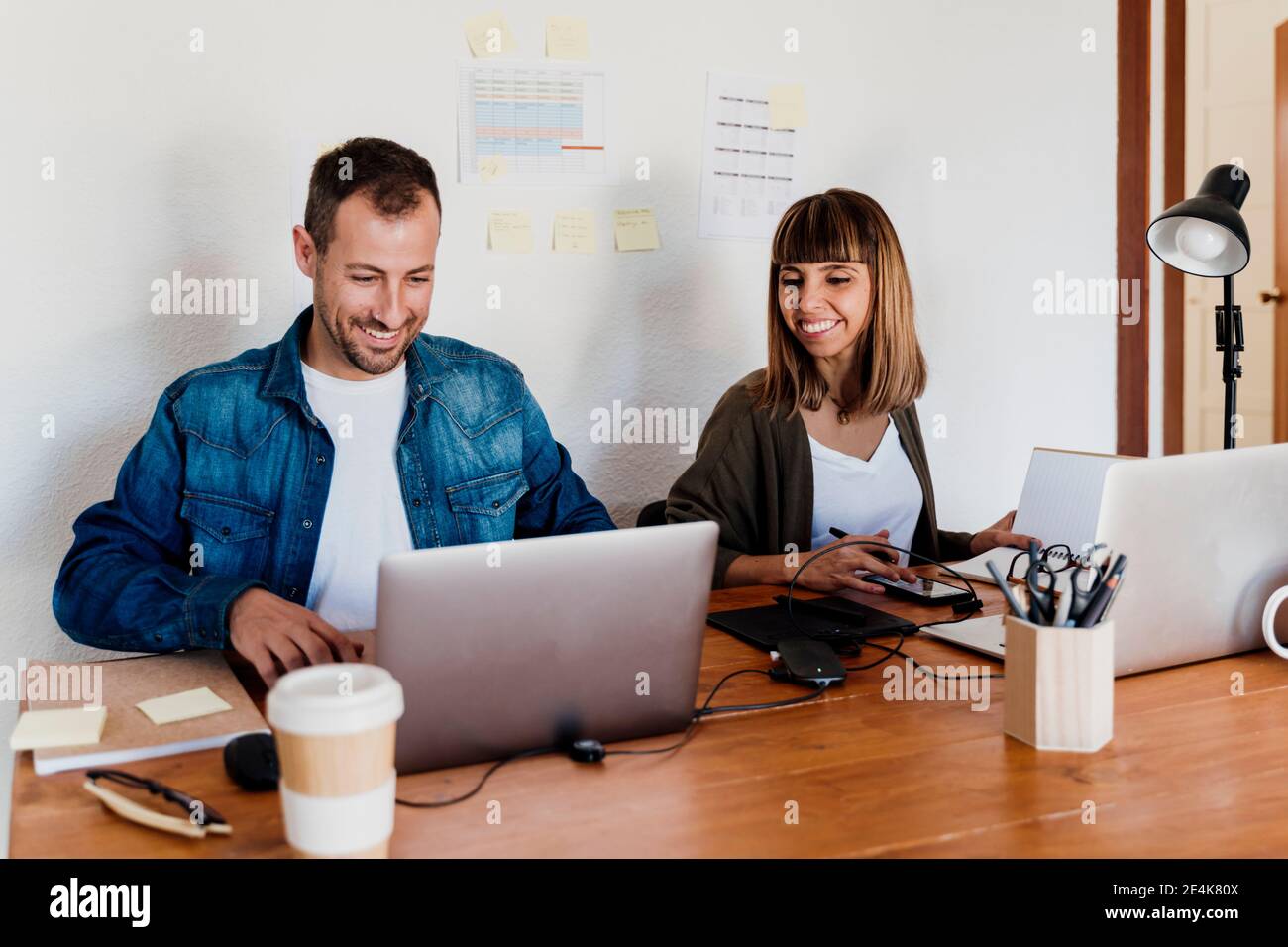 Smiling business couple working together from home in living room Stock Photo