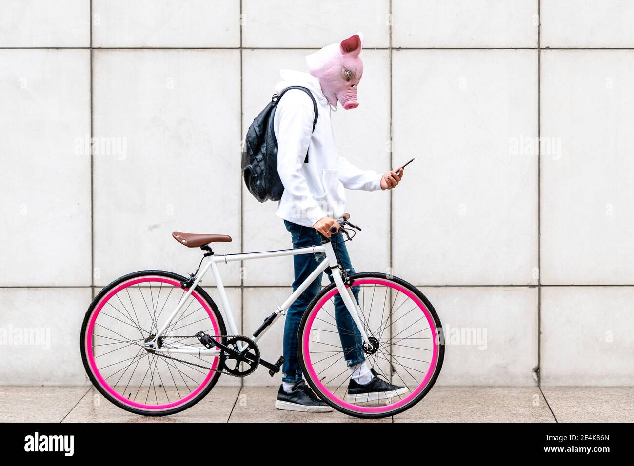 Young man using smart phone walking with bicycle on footpath Stock Photo