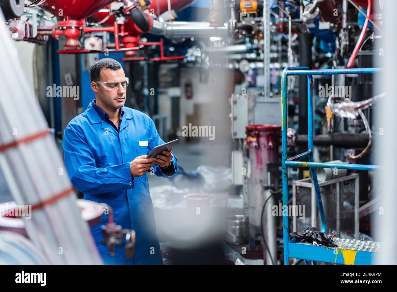 Male technician using digital tablet while working in factory Stock Photo