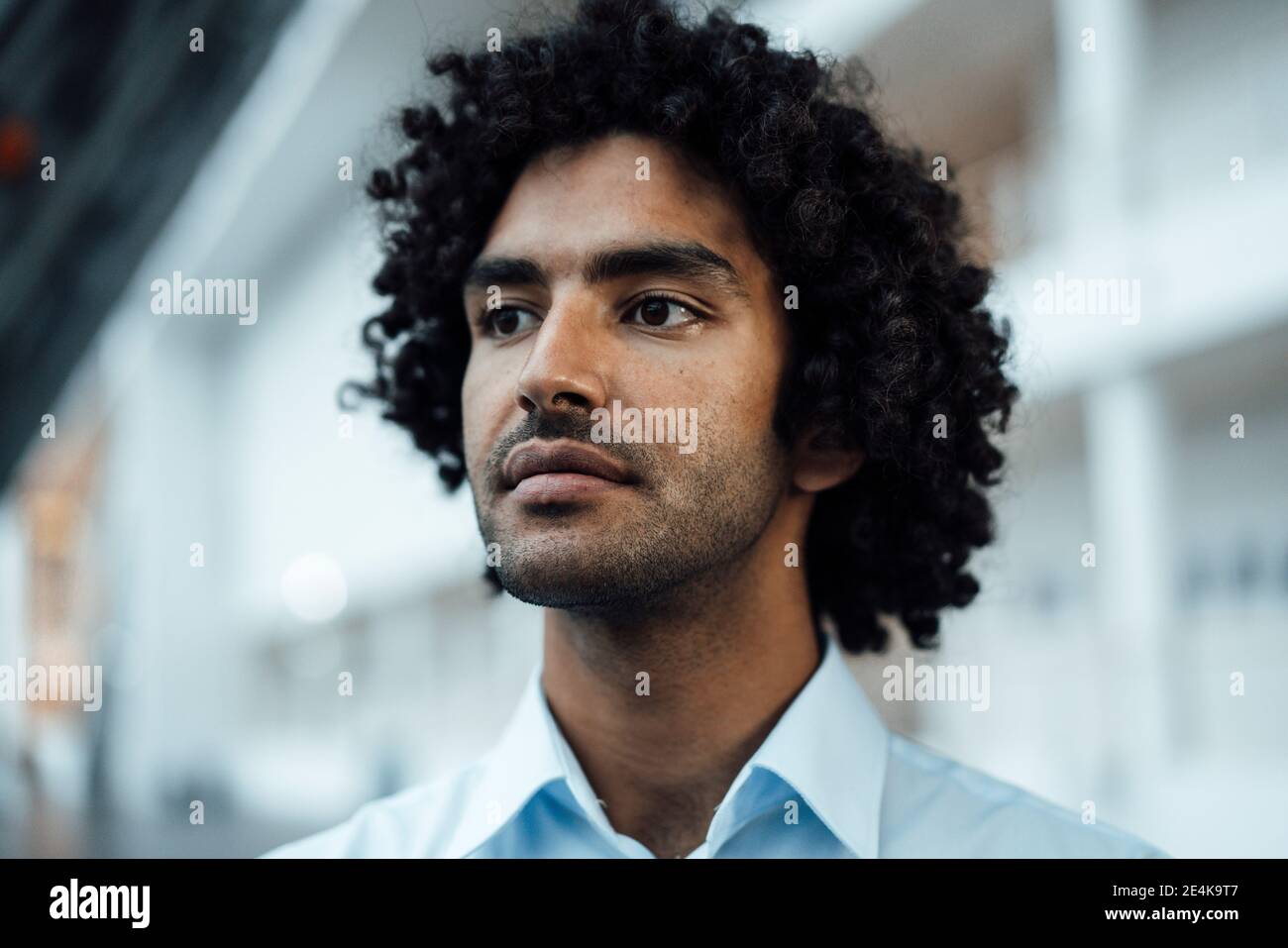 Thoughtful young male entrepreneur looking away at workplace Stock Photo