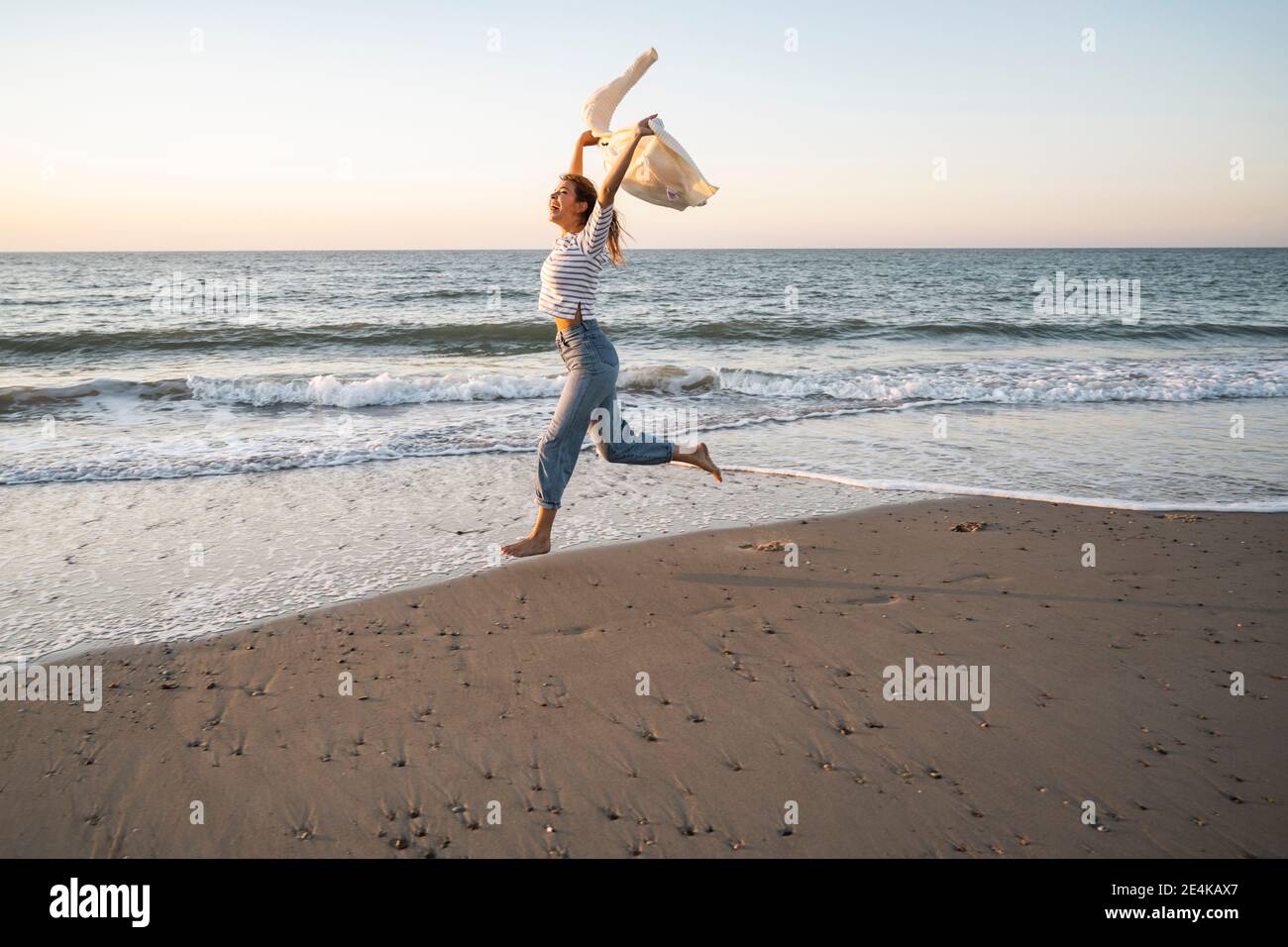 Woman sunset beach carefree hi-res stock photography and images - Alamy