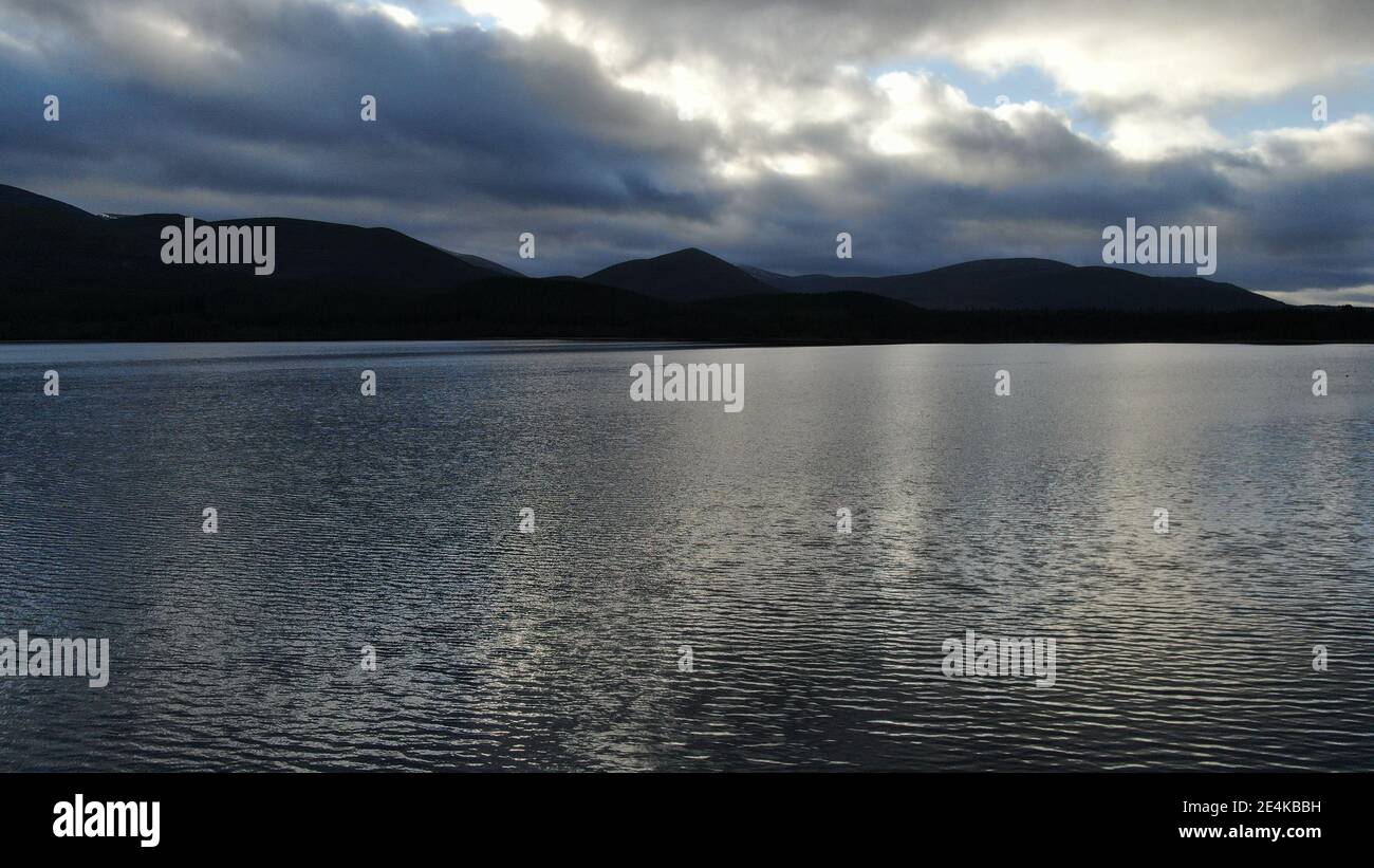 Aerial view of a Scottish loch with the Cairngorm mountai. The dark ...