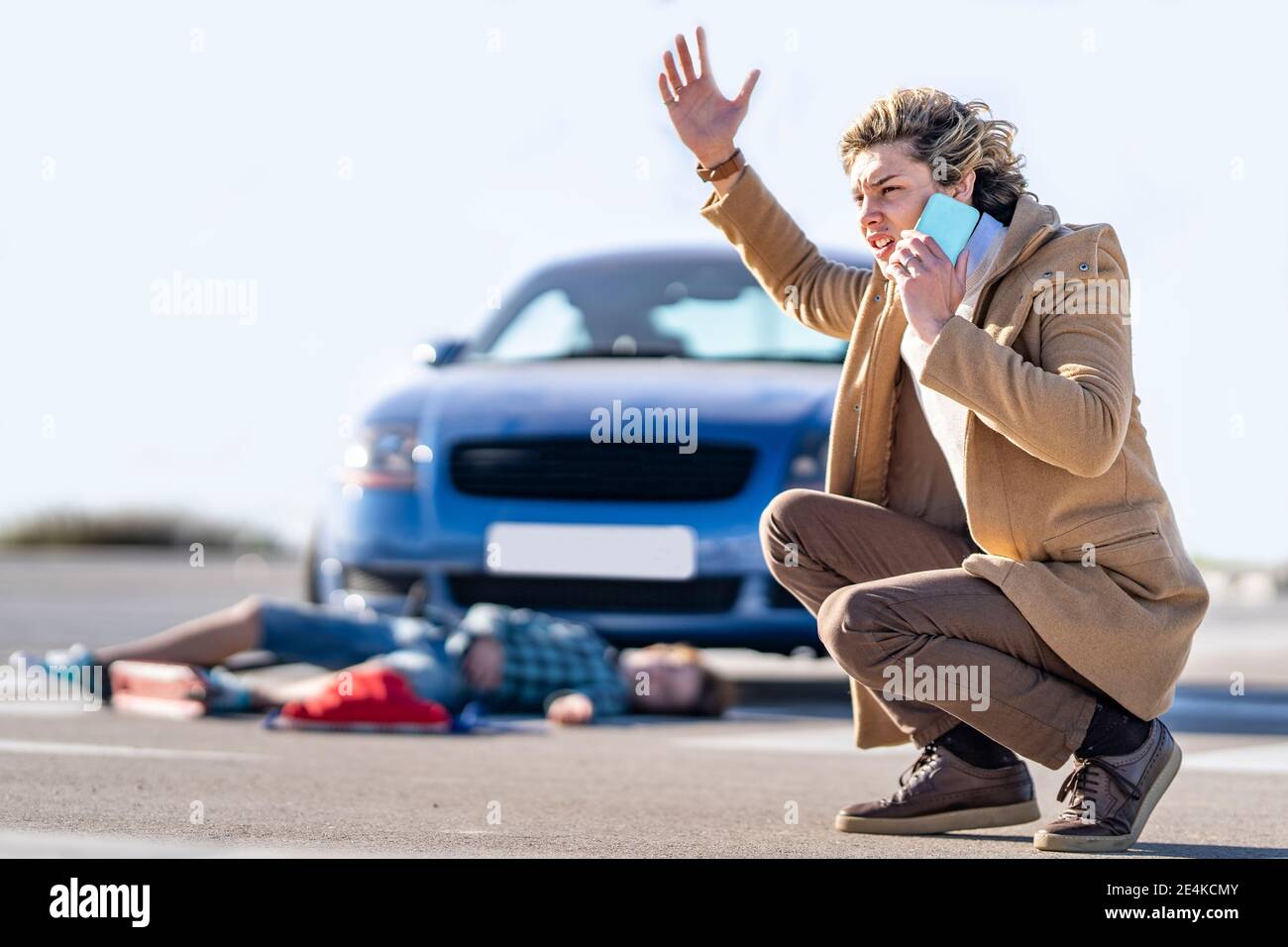 Young man calling help on mobile phone with boy in background 