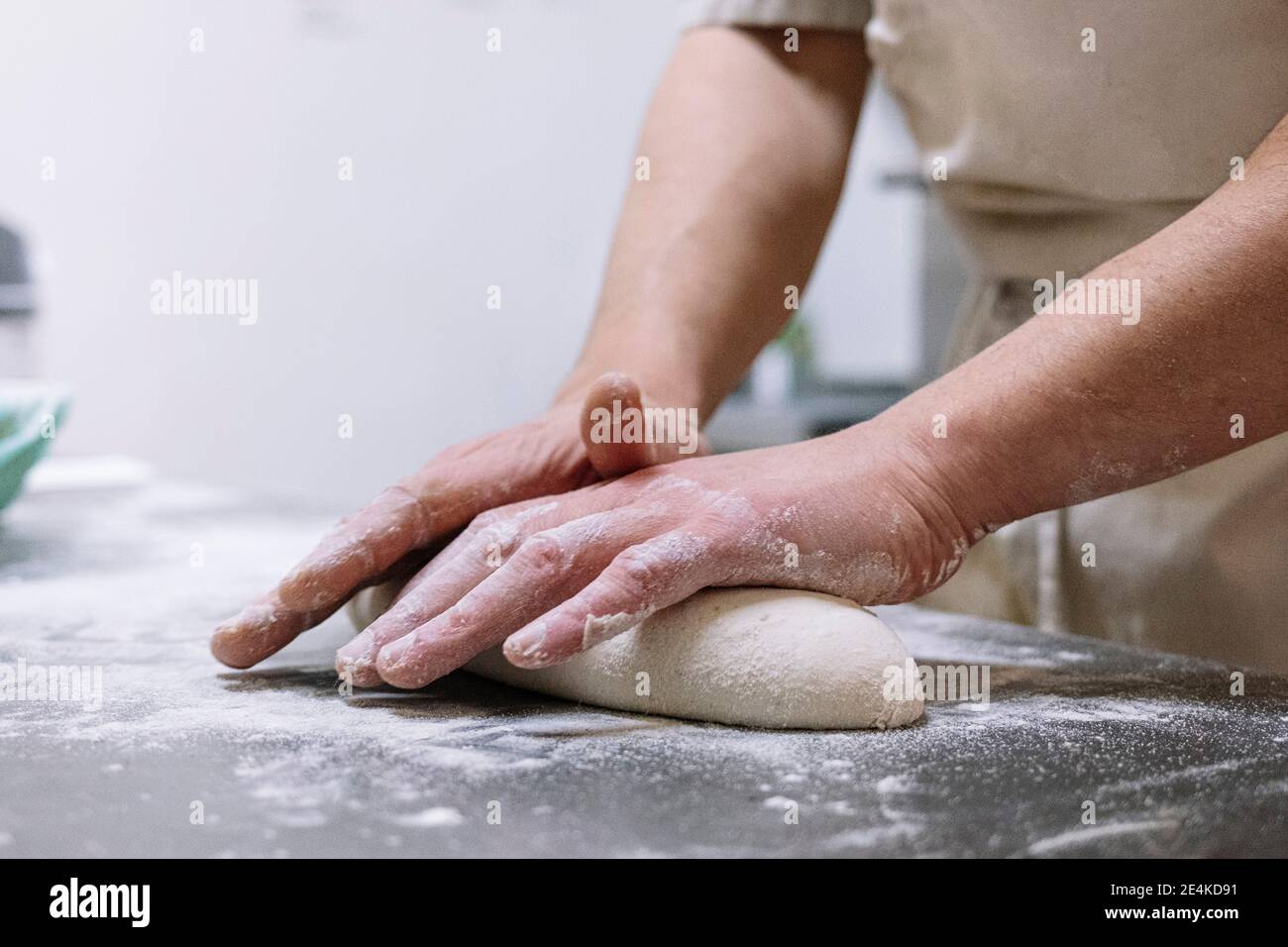 Male chef kneading flour dough on kitchen counter in bakery Stock Photo ...