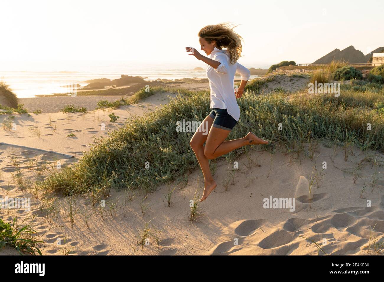 Woman sunset beach carefree hi-res stock photography and images - Alamy