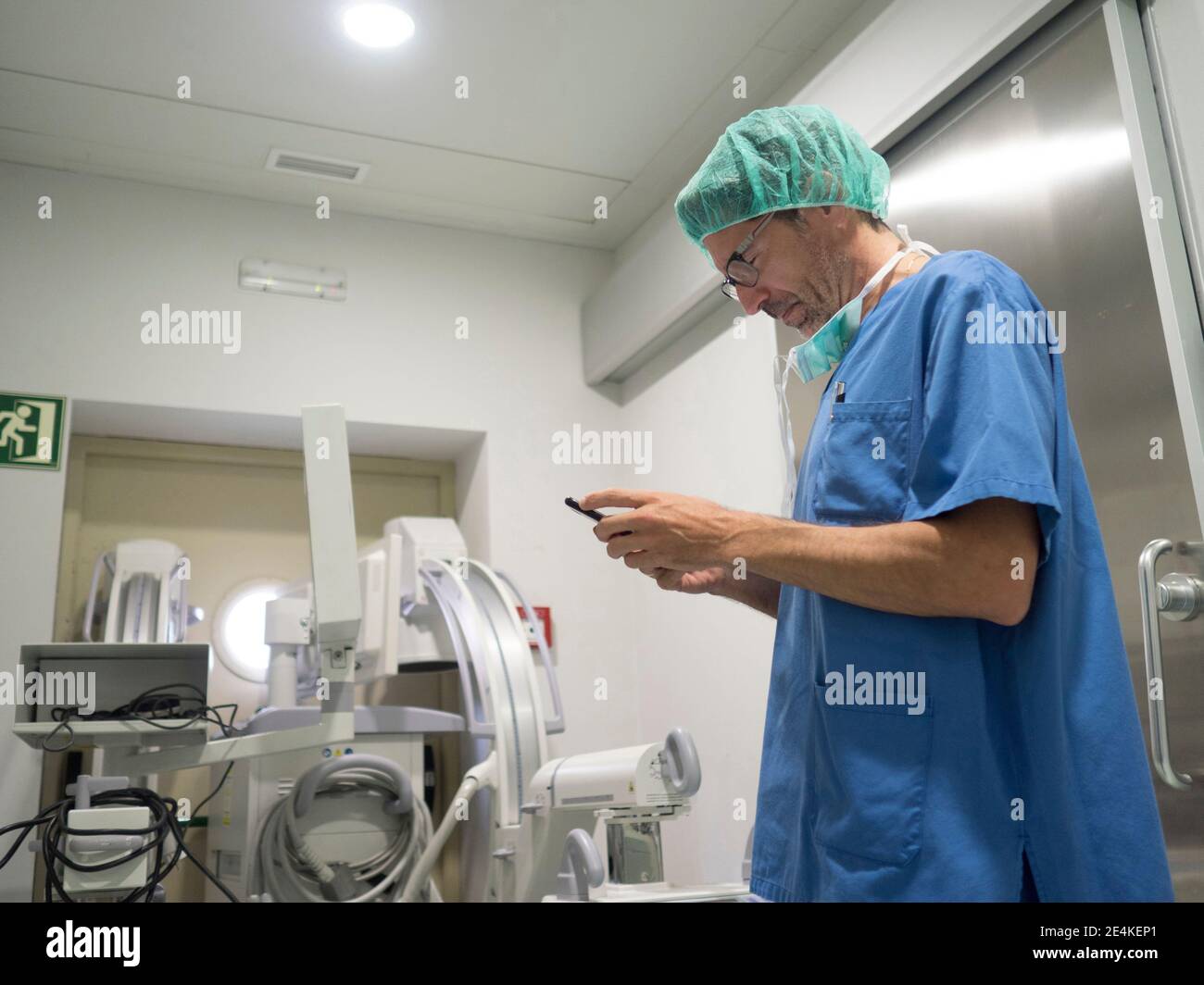 Male orthopedic surgeon performing operation on patient knee in ICU Stock Photo