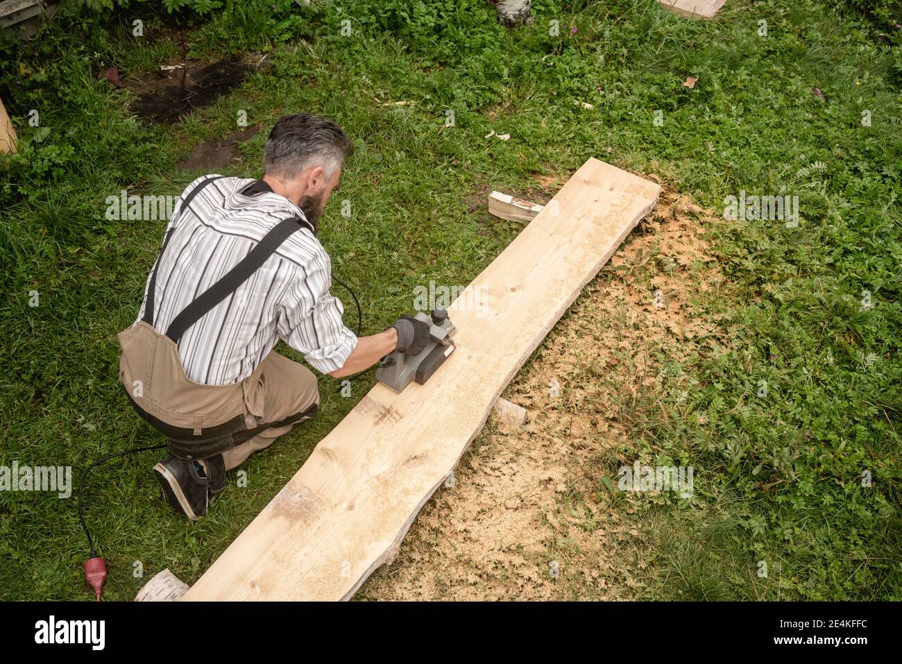 Carpenter sawing plank with circular saw Stock Photo