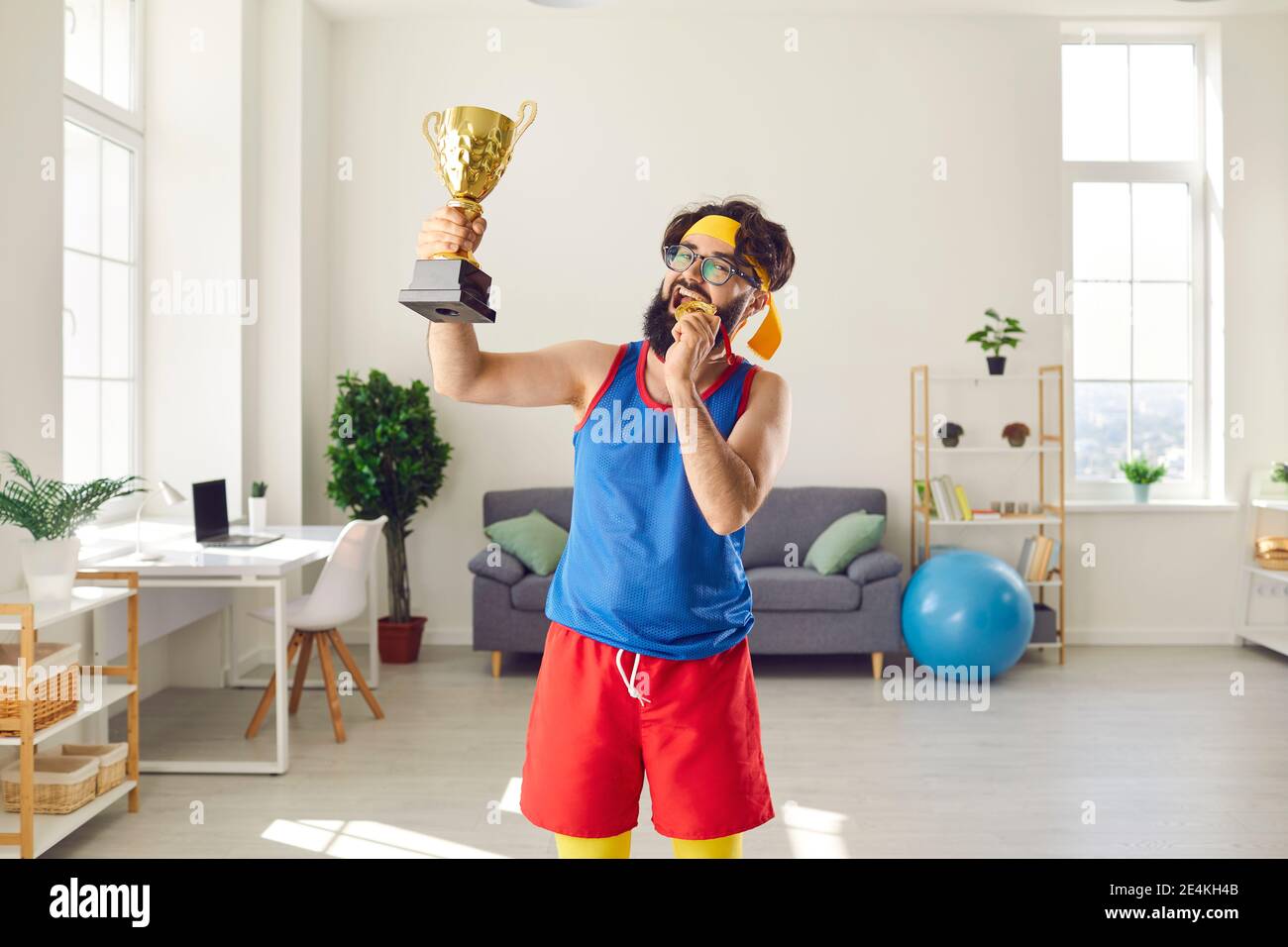 Crazy, goofy, funny, proud sport contest winner showing off his gold cup and medal Stock Photo
