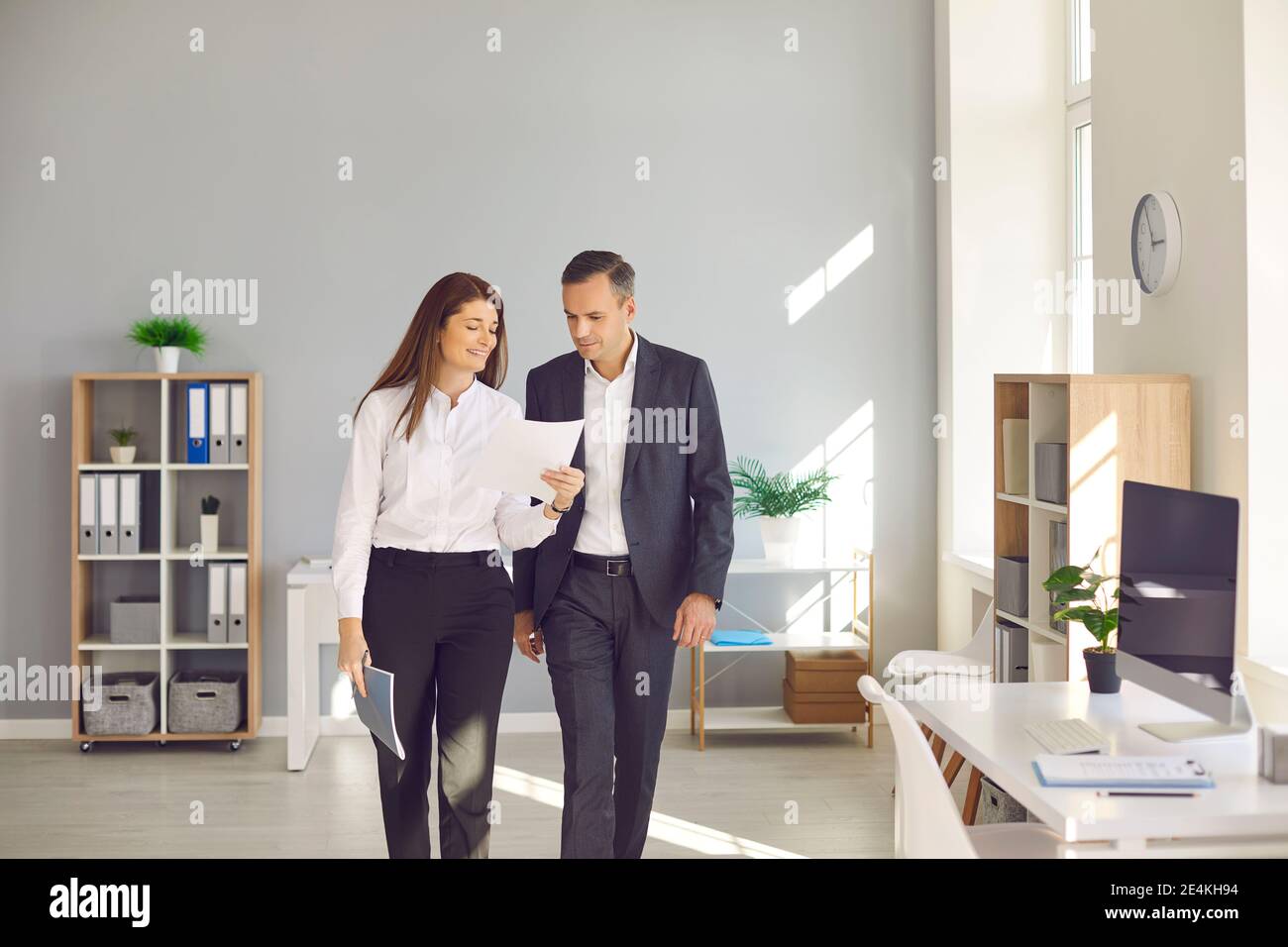 Smiling friendly business woman showing documents to her colleague during a meeting in the office. Stock Photo