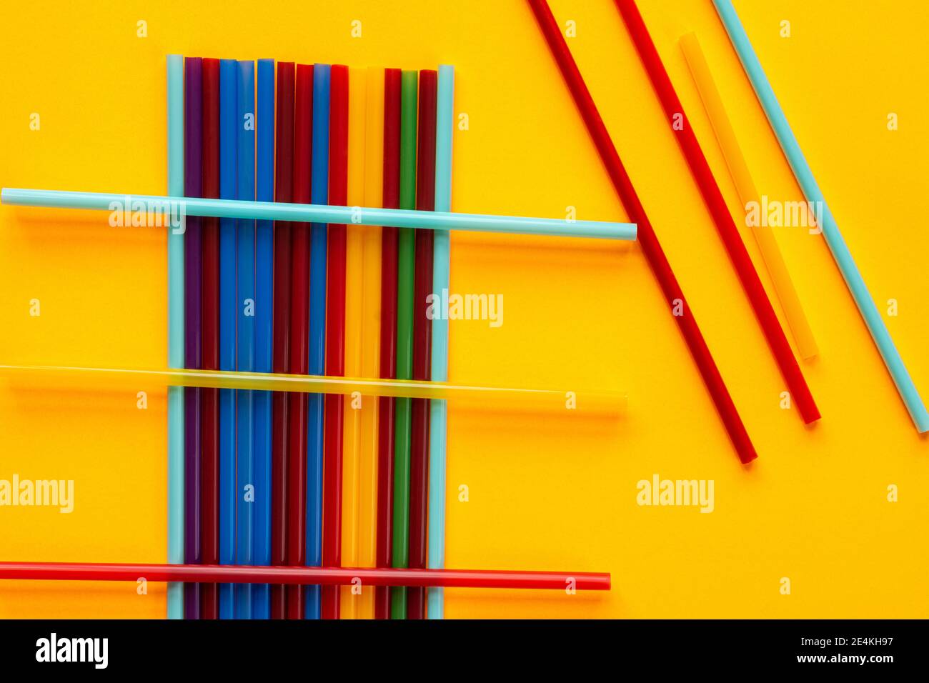 Multi-colored cocktail tubes lie on a yellow background Stock Photo