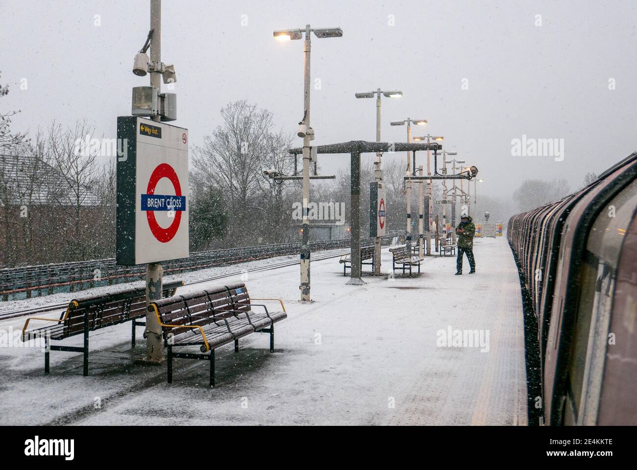 A lone man exits or alights train onto a snow-covered platform at Brent Cross tube station. The platform is icy and snow covered due to a lack of grit salt being applied by Transport for London staff despite weather warnings. London. UK Weather. Stock Photo