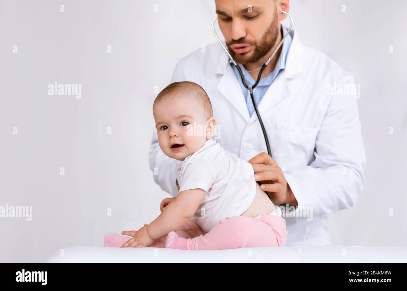 Doctor Examining Baby Listening To Her Lungs Over White Background Stock Photo