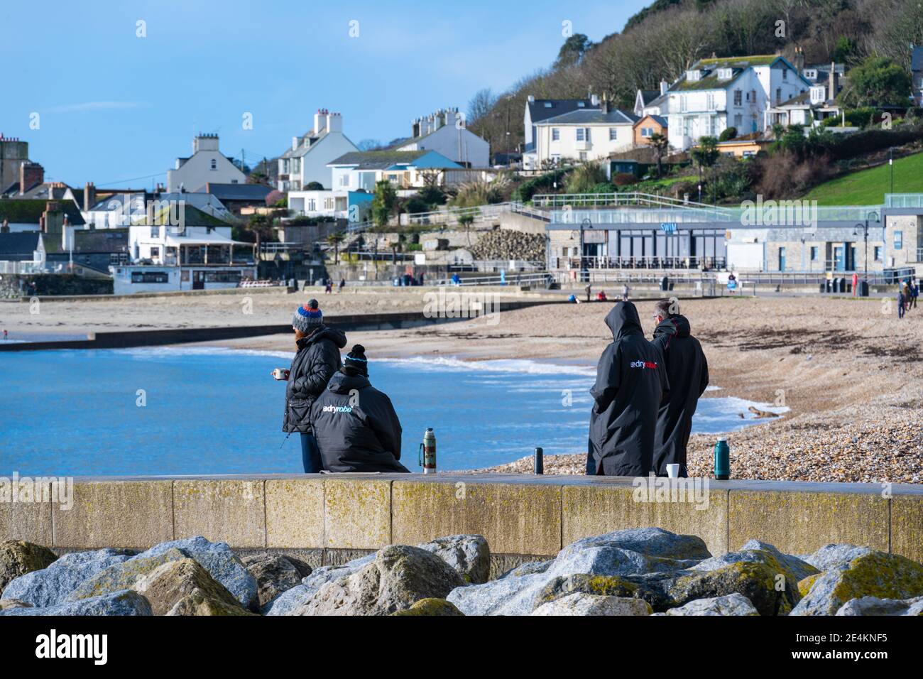 Lyme Regis, Dorset, UK. 24th January 2021. UK Weather: A bright, sunny and cold day at the seaside resort town of Lyme Regis.  Locals enjoy flask of coffee on the almost deserted beach during the third national lockdown. Credit: Celia McMahon/Alamy Live News. Stock Photo