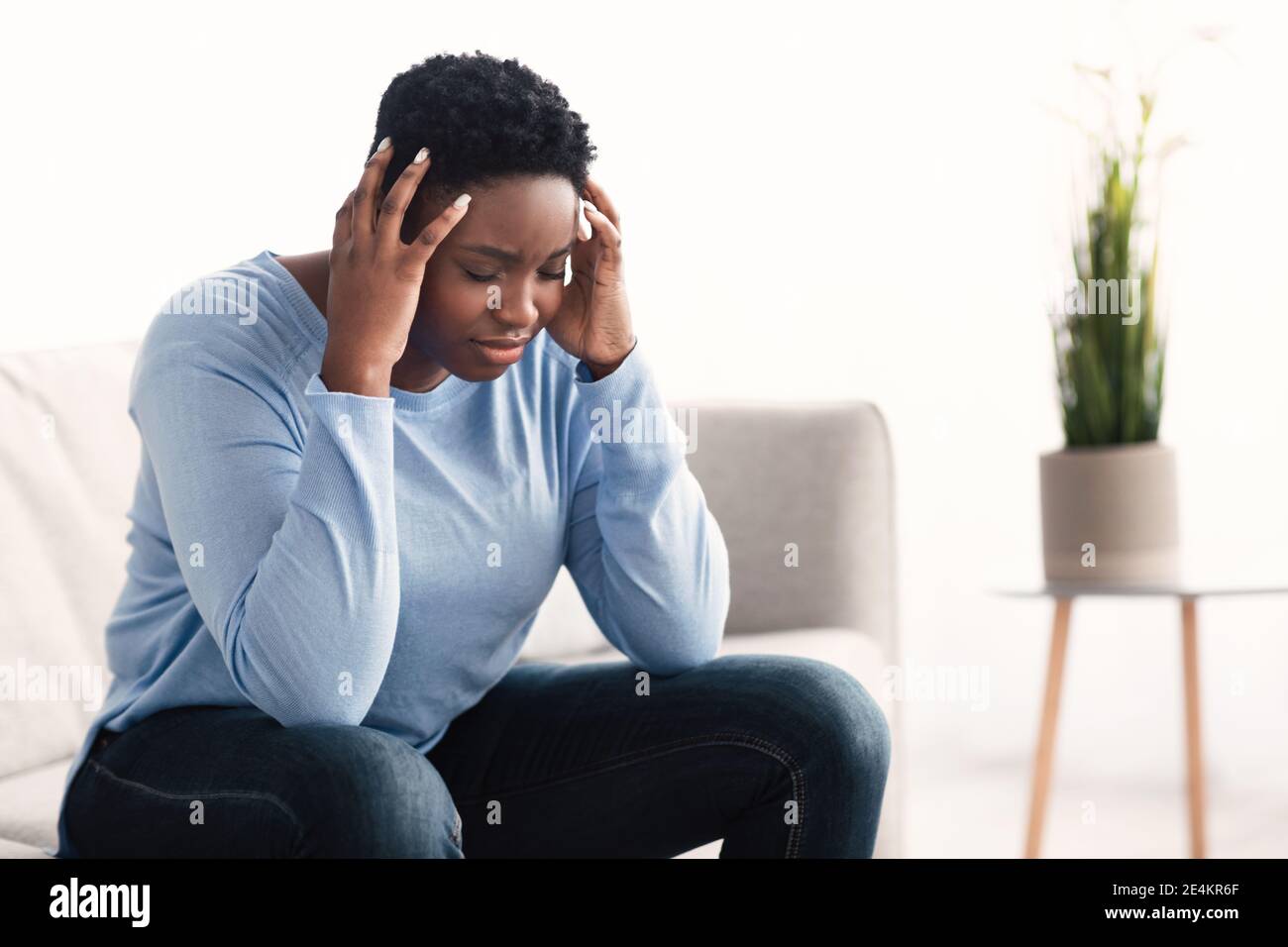 Black woman touching her head feeling stress Stock Photo