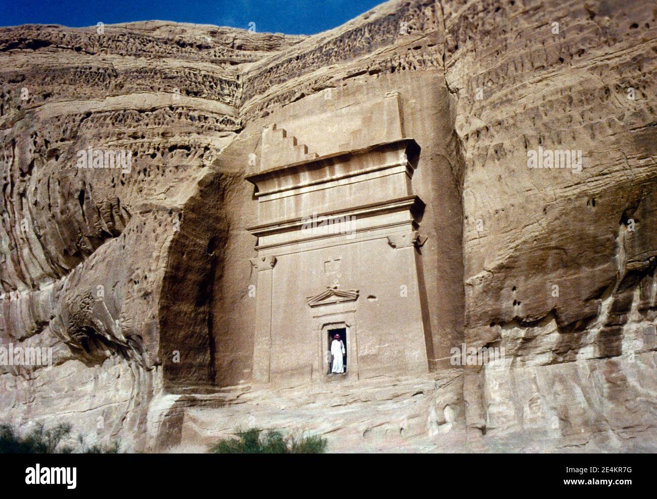 Mada'in Saleh Saudi Arabia Man standing at the Entrance Portal of Nabataean Tomb Near The Qasr Al-Bint area Stock Photo