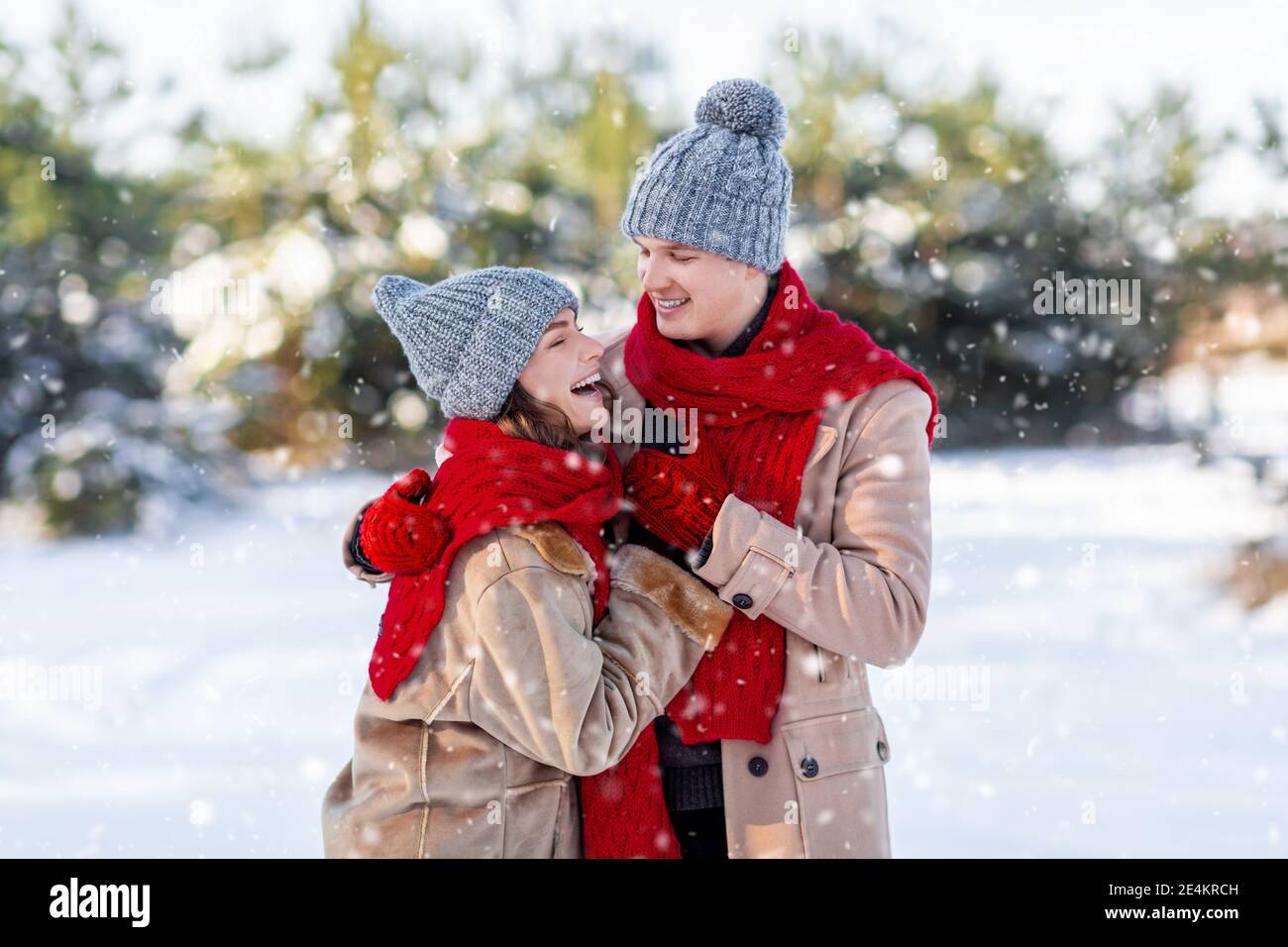 Millennial family spending day in park on snowy sunny day Stock Photo