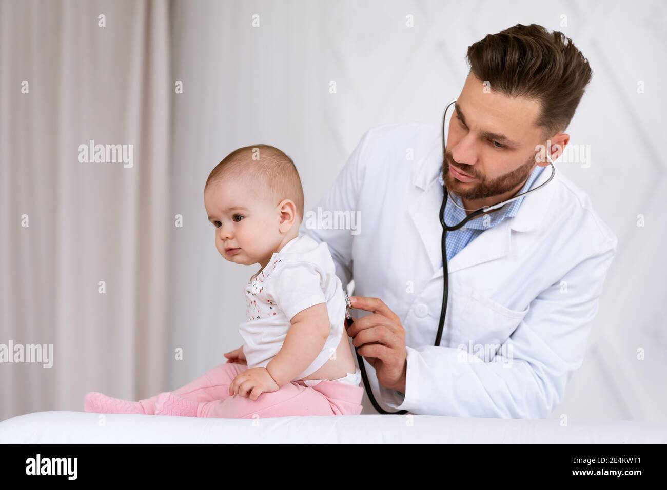 Doctor Examining Toddler Listening To Lungs With Stethoscope In Clinic Stock Photo