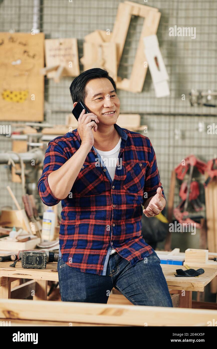 Carpenter talking on phone with customer Stock Photo