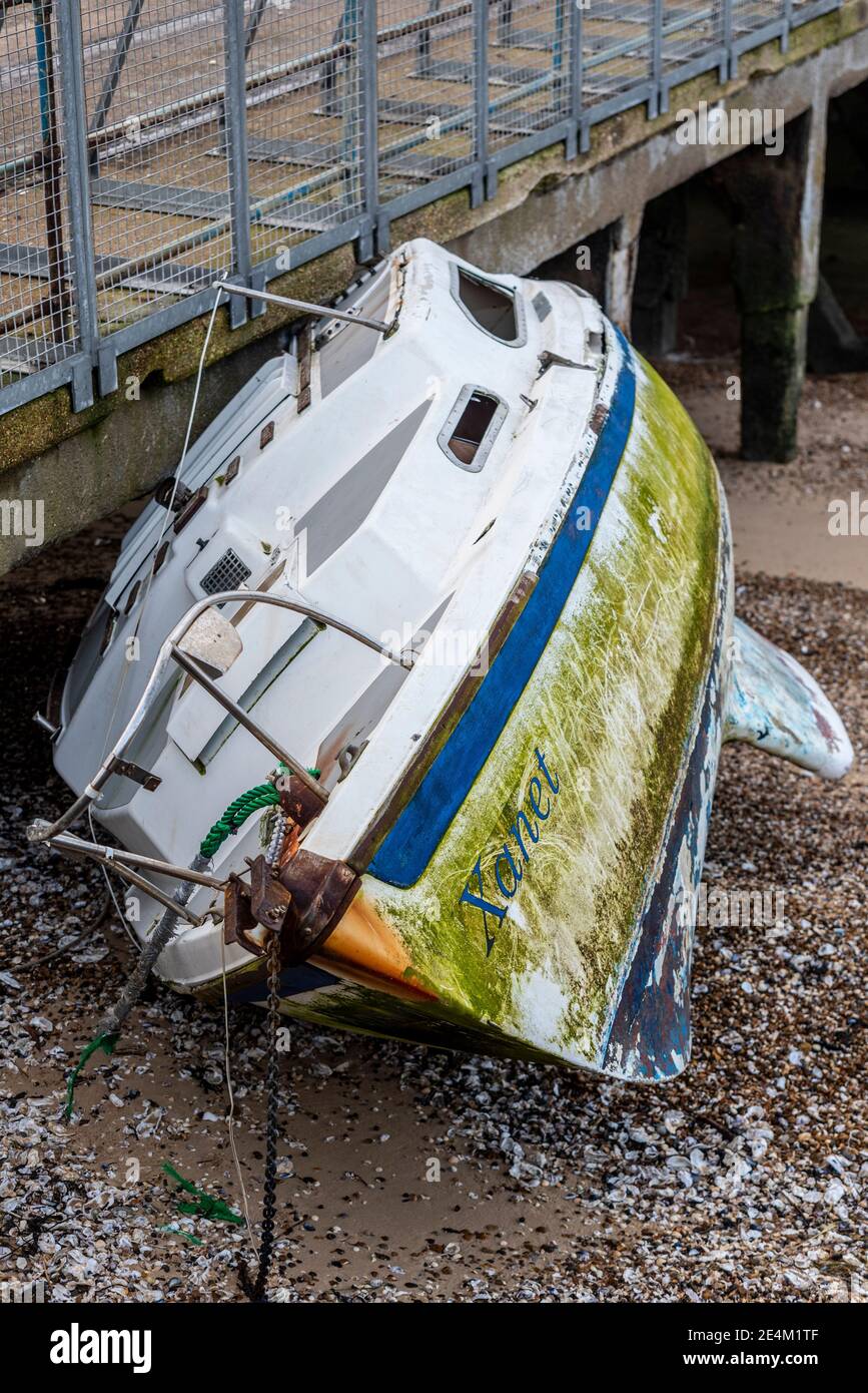 Boat named Xanet washed up onto the beach by stormy seas. Washed against Barge Pier, Shoeburyness, Essex, UK, on MoD land off limits due to ordnance Stock Photo
