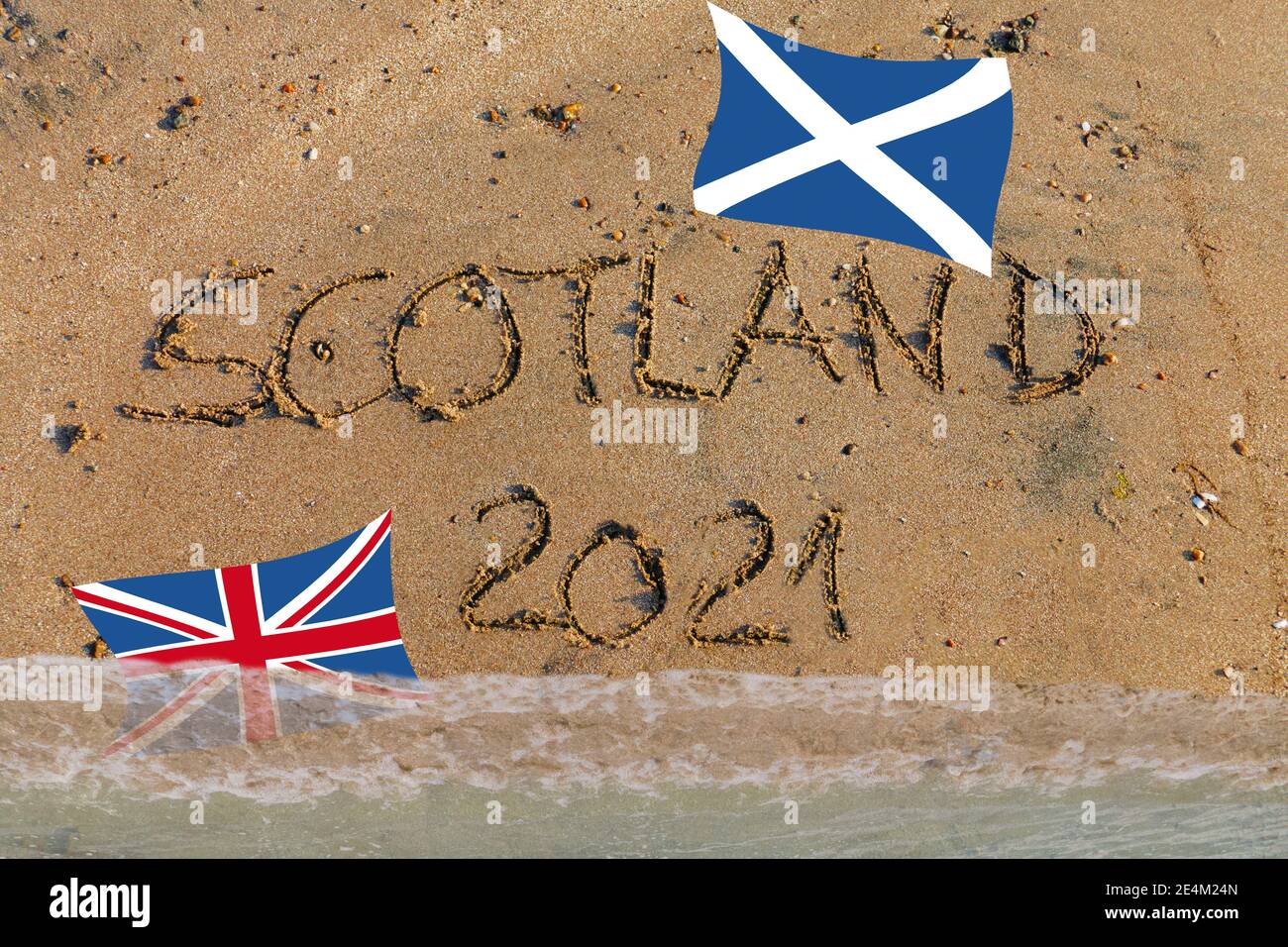 Scotland 2021 in Sand geschrieben, Schottische Flagge oben, Britische Flagge wird vom Wasser überflutet Stock Photo