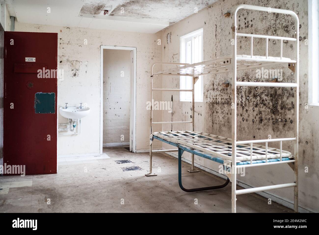 Prison cell block victorian British English jail house bunk bed room lock up high security room derelict old new category A B C custody mouldy bedroom Stock Photo