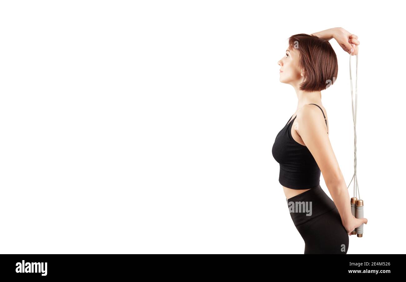 young beautiful woman in black leggings and top doing sports and yoga indoors, on a white background, isolate Stock Photo