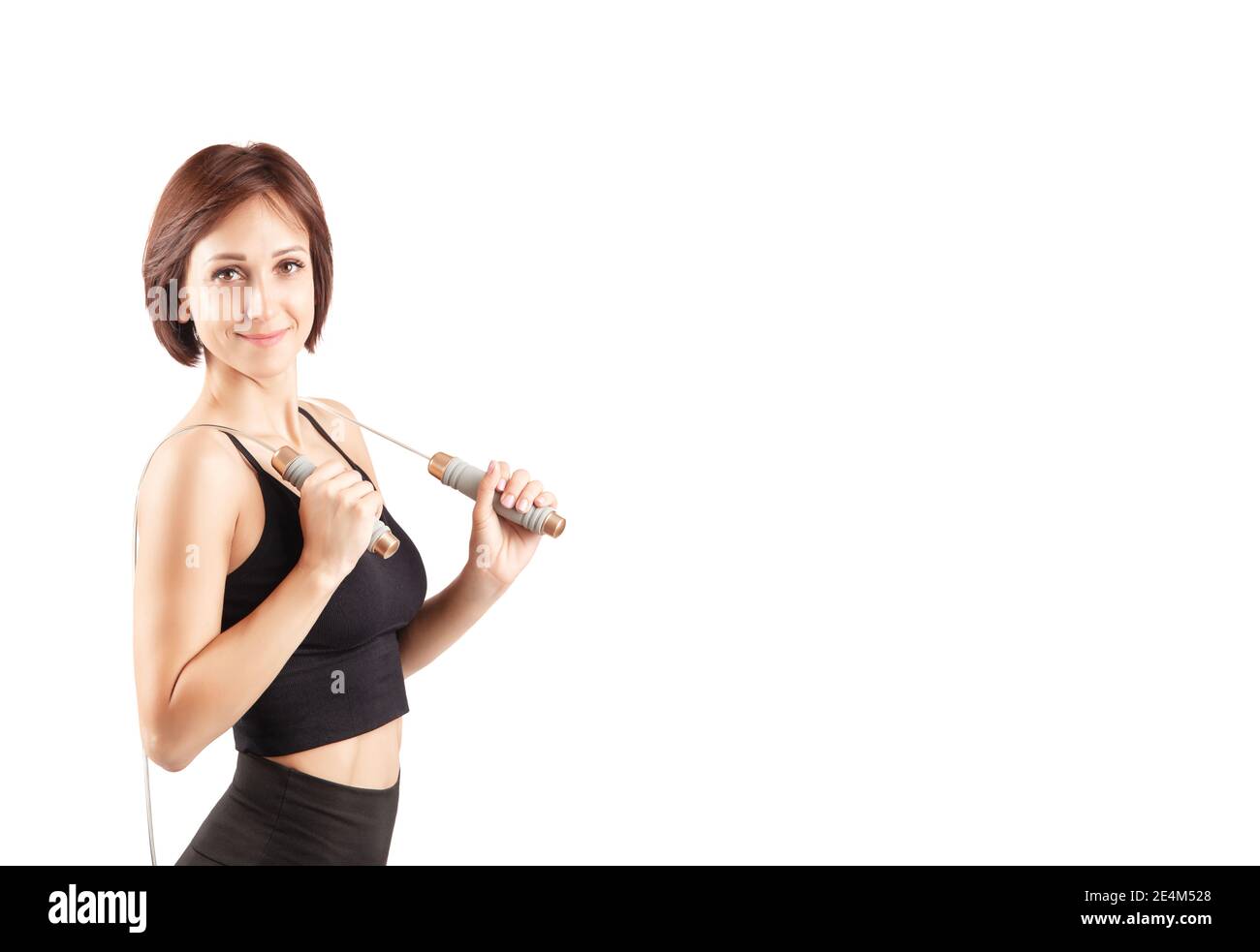 young beautiful woman in black leggings and top doing sports and yoga indoors, on a white background, isolate Stock Photo