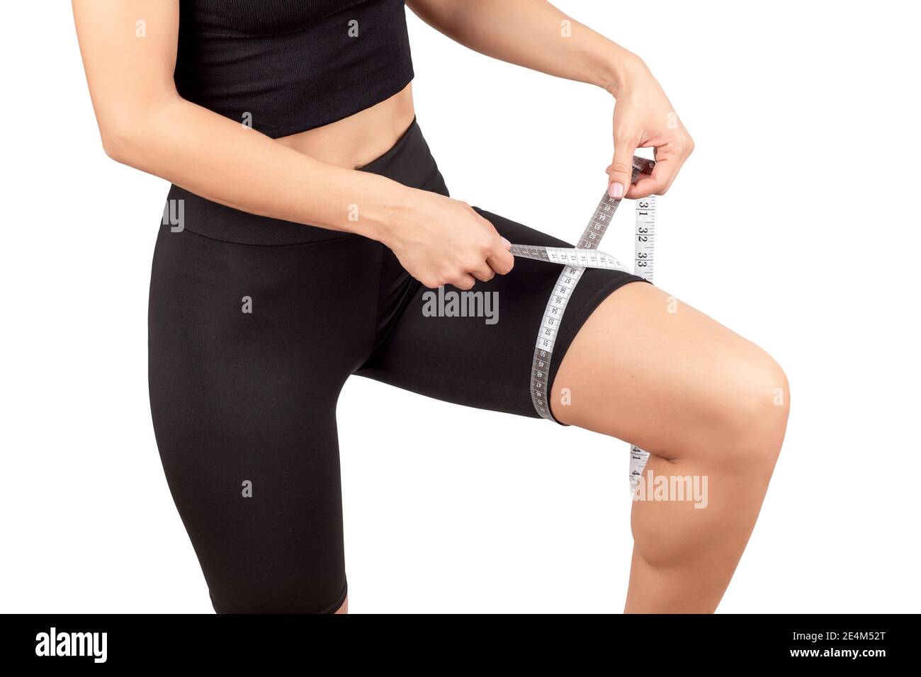 young beautiful woman in black leggings and top doing sports and yoga indoors, on a white background, isolate Stock Photo