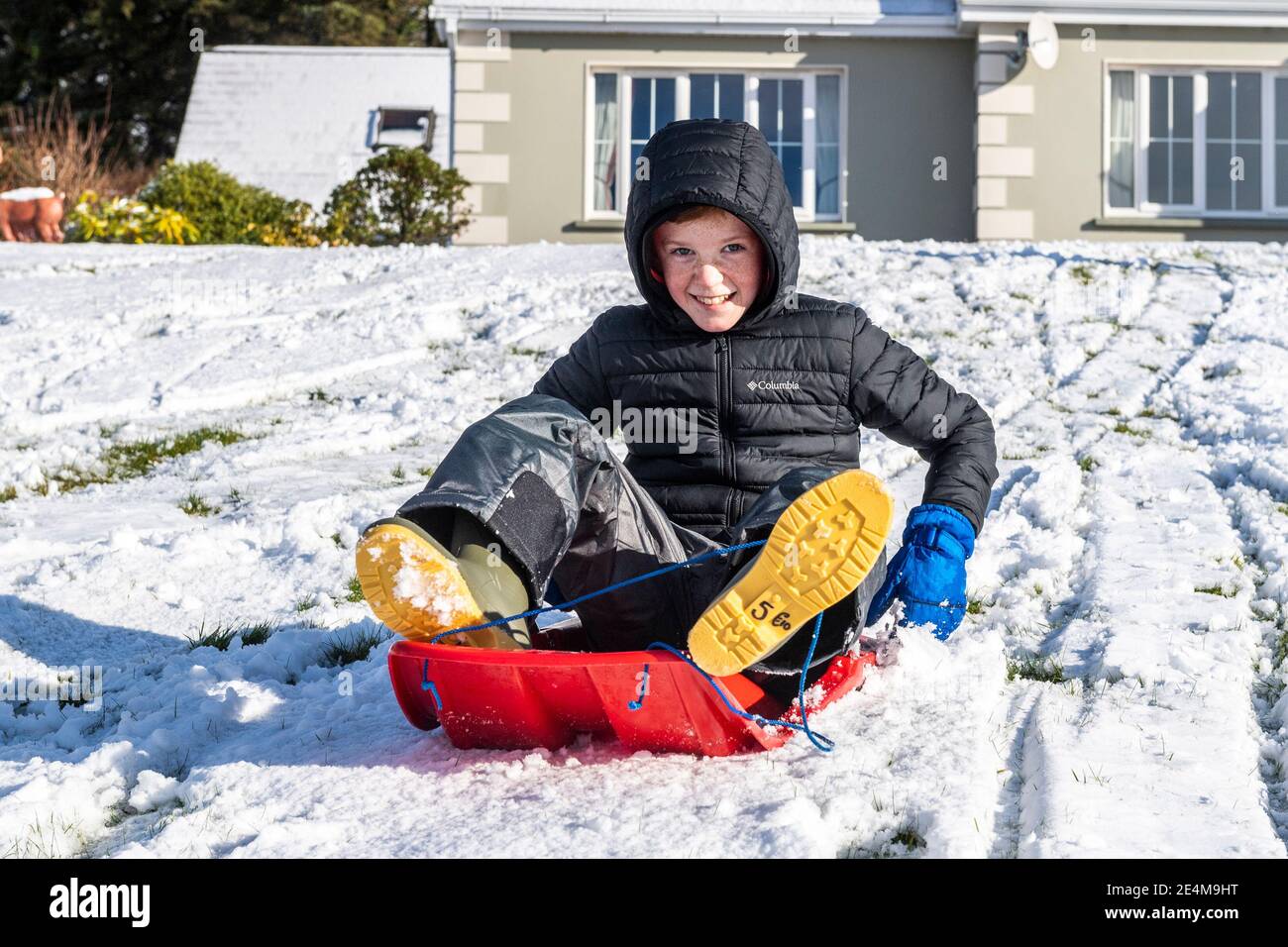Béal Atha'n Ghaorthaidh, West Cork, Ireland. 24th Jan, 2021. West Cork has  been hit by heavy snow overnight and today. Éanna 'Céilleachair took the  chance to do some sledging in his front