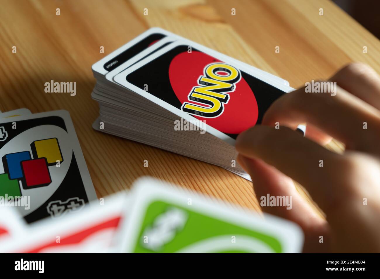 Bangkok, Thailand - January 23, 2021 : A man playing UNO card game. Stock Photo