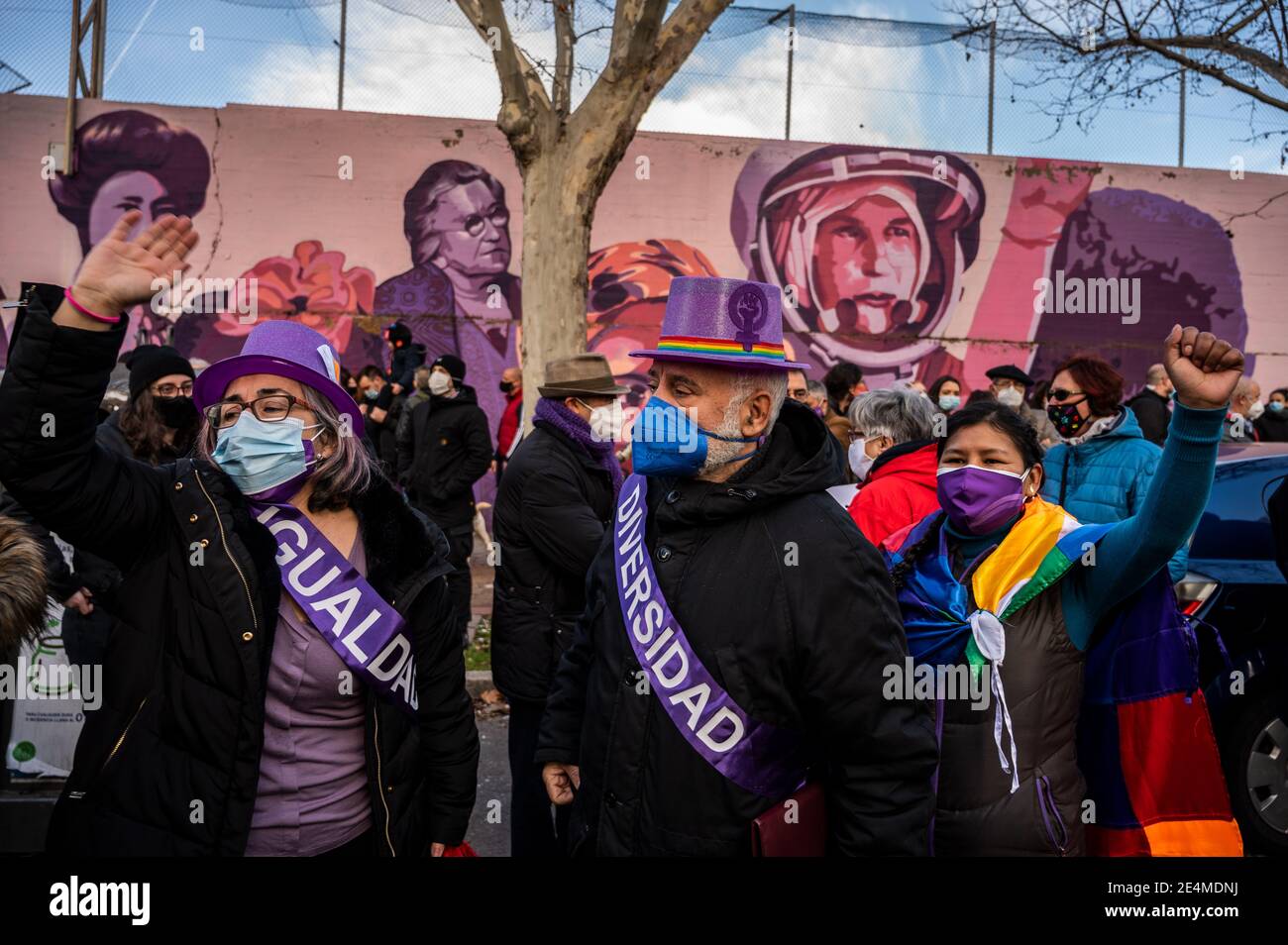 Madrid, Spain. 24th Jan, 2021. Protesters raise hands next to a feminist mural named 'Union makes force', during a protest against the removal of the mural proposed by far-right party VOX. In the mural appear the faces of 15 women who are part of history for their fight in favor of equality: Angela Davis, Frida Kahlo, Nina Simone, Rigoberta Menchu, Lucia Sanchez Saornil, Rosa Arauzo, Valentina Tereshkova, Chimamanda Ngozi, Emma Goldman, Kanno Sugato, Liudmila Pavlichenko, Billy Jean King, Gata Cattana, Rosa Parks, and Comandanta Ramona. Credit: Marcos del Mazo/Alamy Live News Stock Photo