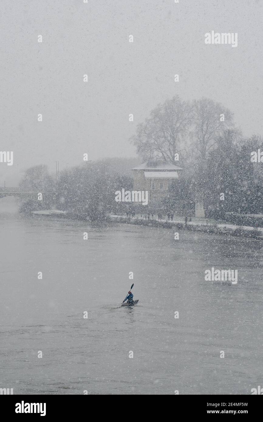 Richmond Upon Thames, London | UK -  2021.01.24: Man in canoe on a snowy Sunday morning on the river Thames Stock Photo