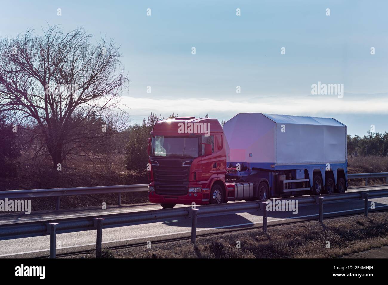 Truck with a specific semi-trailer for transporting glass and glass while driving on the highway. Stock Photo