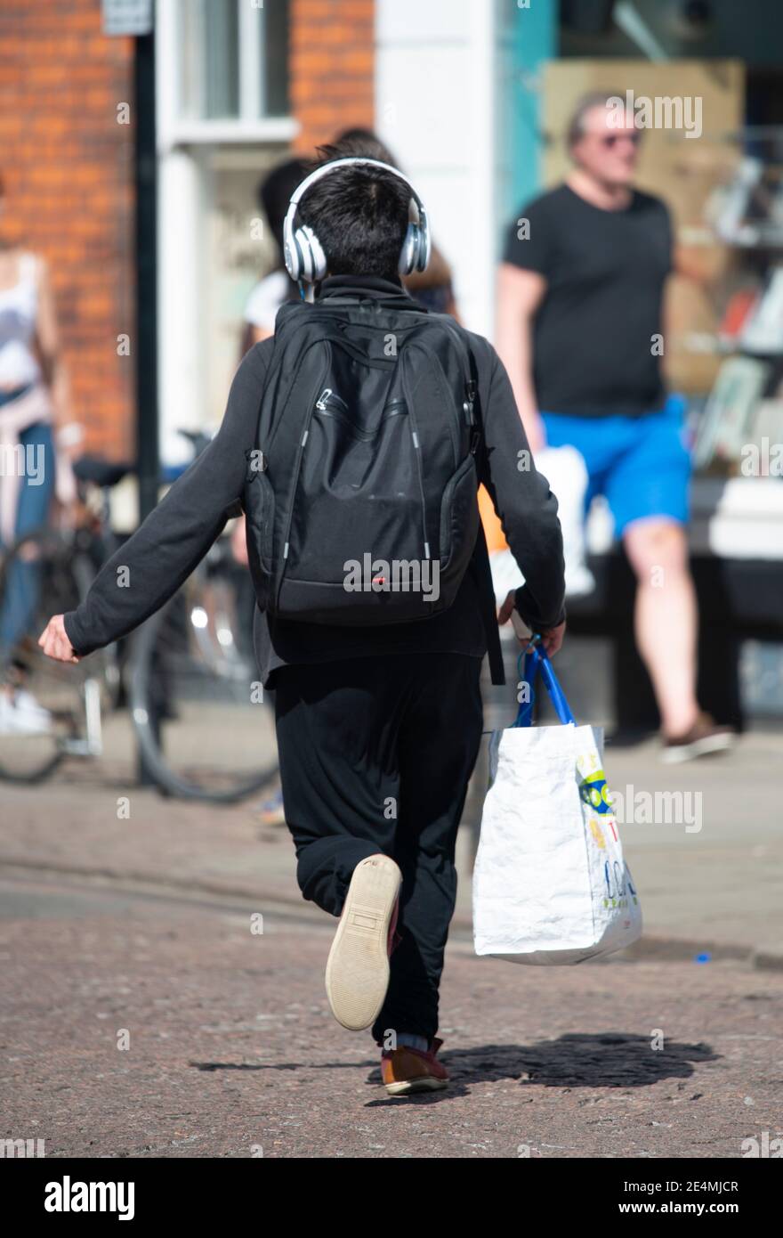 Man running with headphones and shopping bag. Carrier bag getaway Stock Photo