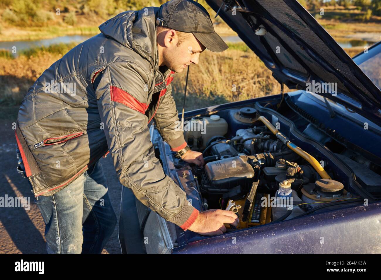 Tired man tries to repair a broken car Stock Photo - Alamy