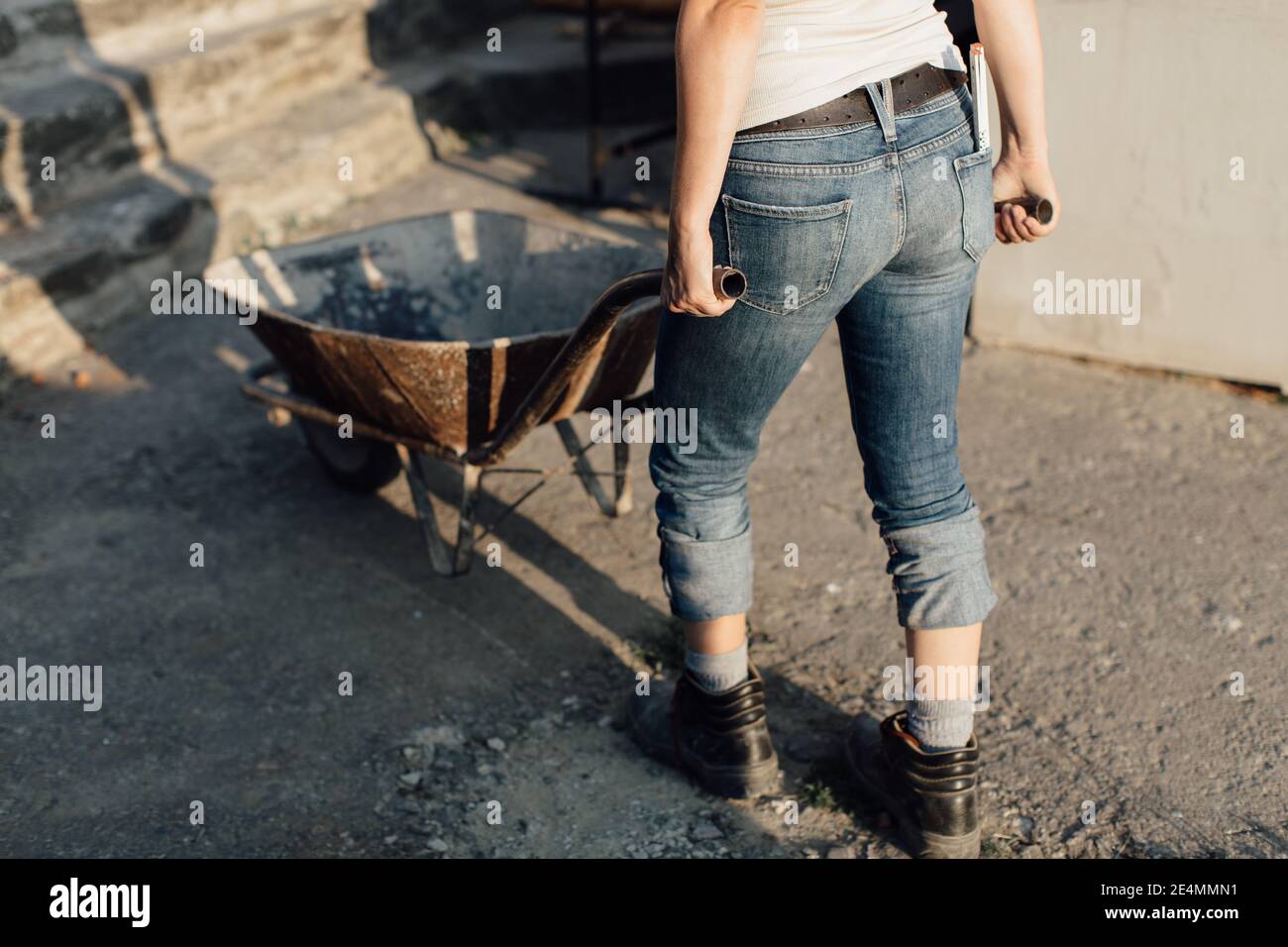 Female worker midsection pushing an empty wheelbarrow Stock Photo - Alamy