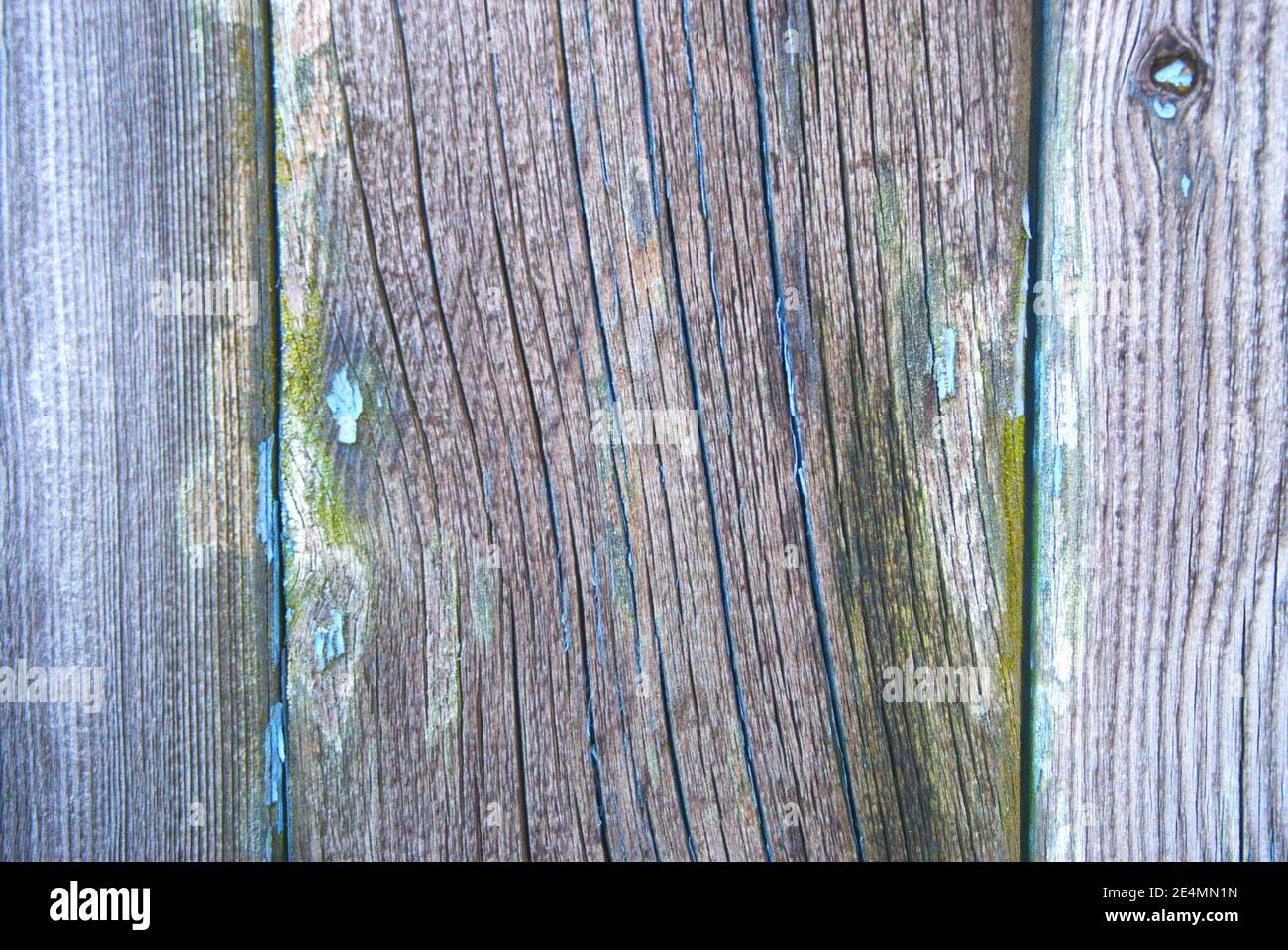 Close-up of an abstract pattern made by wood and the remains of peeling paint on an old garage door. Stock Photo