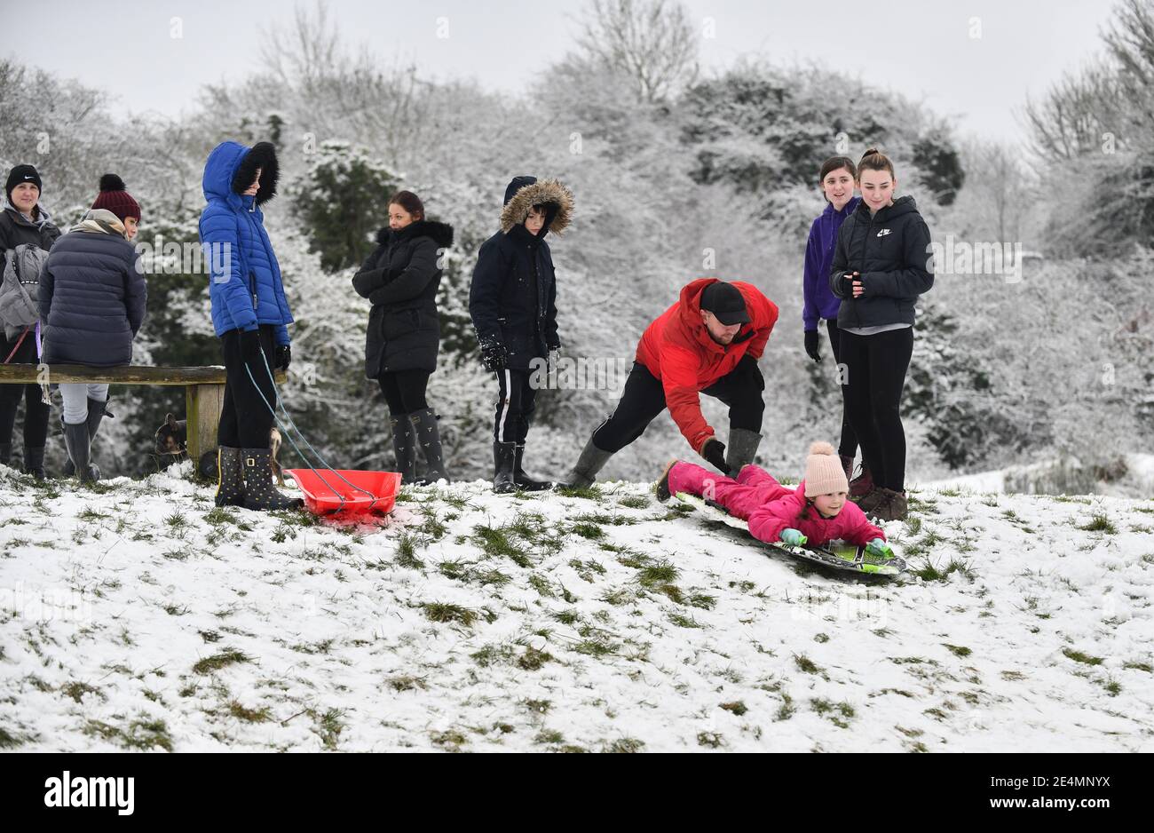 Ironbridge, Shropshire, Uk January 24th 2021. Sledging in the snow with a helping hand from dad on the Ironbridge hills as families have fun in the winter snow. Credit: David Bagnall/Alamy Live News Stock Photo