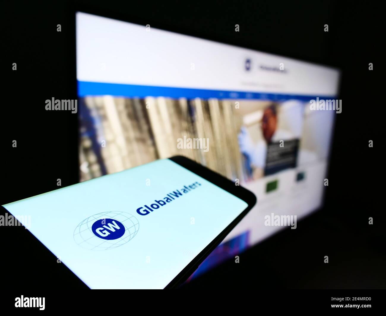 Person holding mobile phone with business logo of Taiwanese semiconductor manufacturer GlobalWafers on screen. Focus on center of phone display. Stock Photo